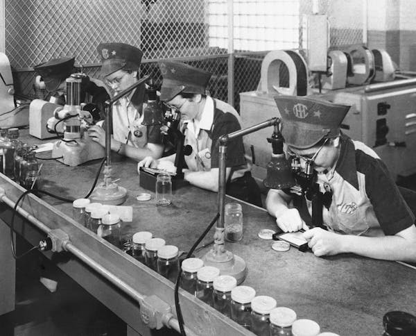 FILE - In this Feb. 10, 1943, file photo, employees of International Harvester inspect ball bearings in Chicago, the smallest being one eighth of an i