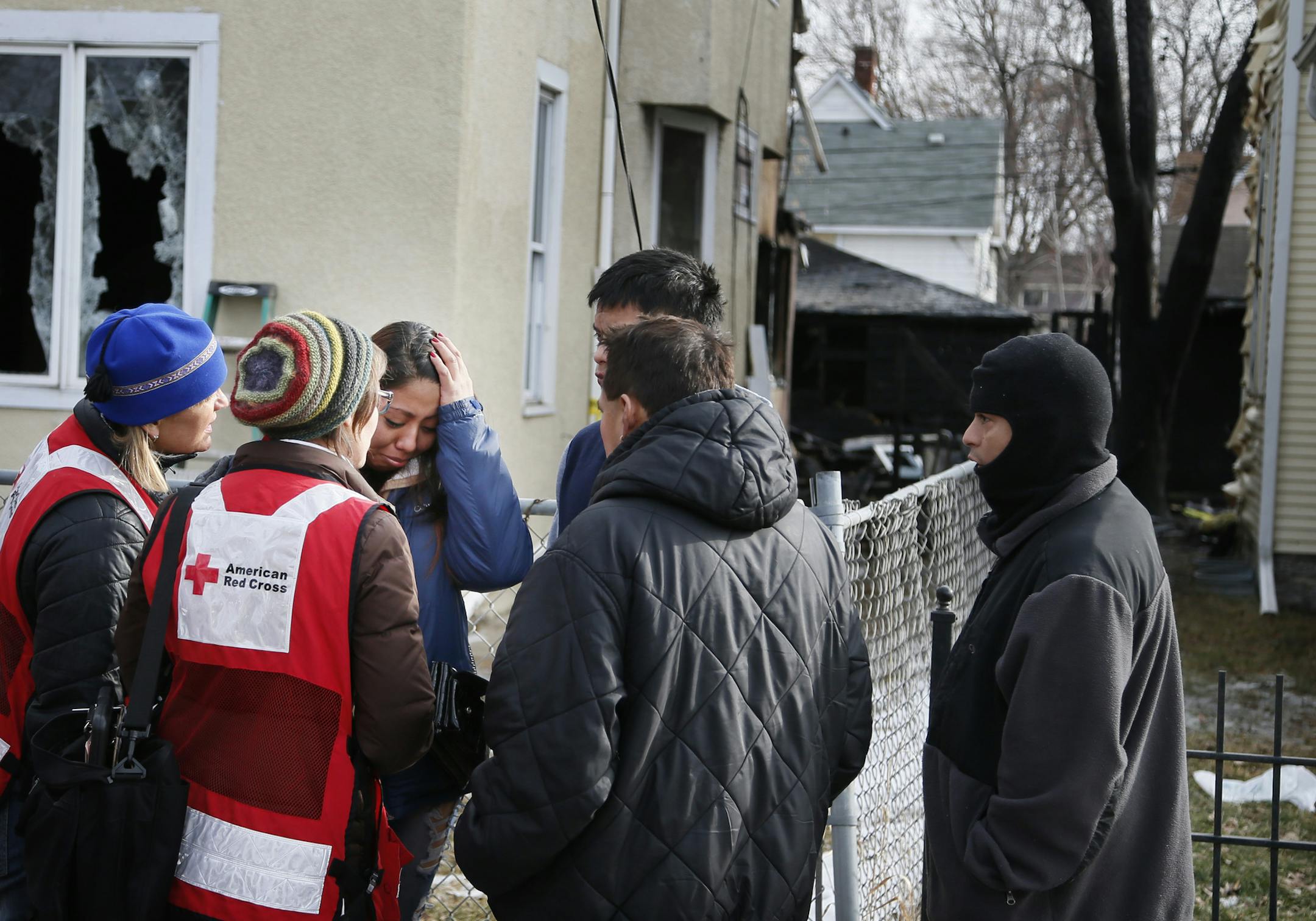 Zvany Santiago (center) wiped tears from her eyes as members of the Red Cross consoled her. Friends gathered at the scene in the 3400 block of Chicago Avenue south Sunday where and early morning fire damaged two homes February 8, 2015 in Minneapolis, MN. The blaze was first reported about 3:20 am and one person was killed in the fire. ] Jerry Holt/ Jerry.Holt@Startribune.com