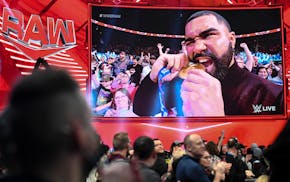 University of Minnesota wrester Gable Steveson bites his Olympic gold medal during WWE Raw Monday, Dec. 13, 2021 at the Xcel Energy Center in St. Paul