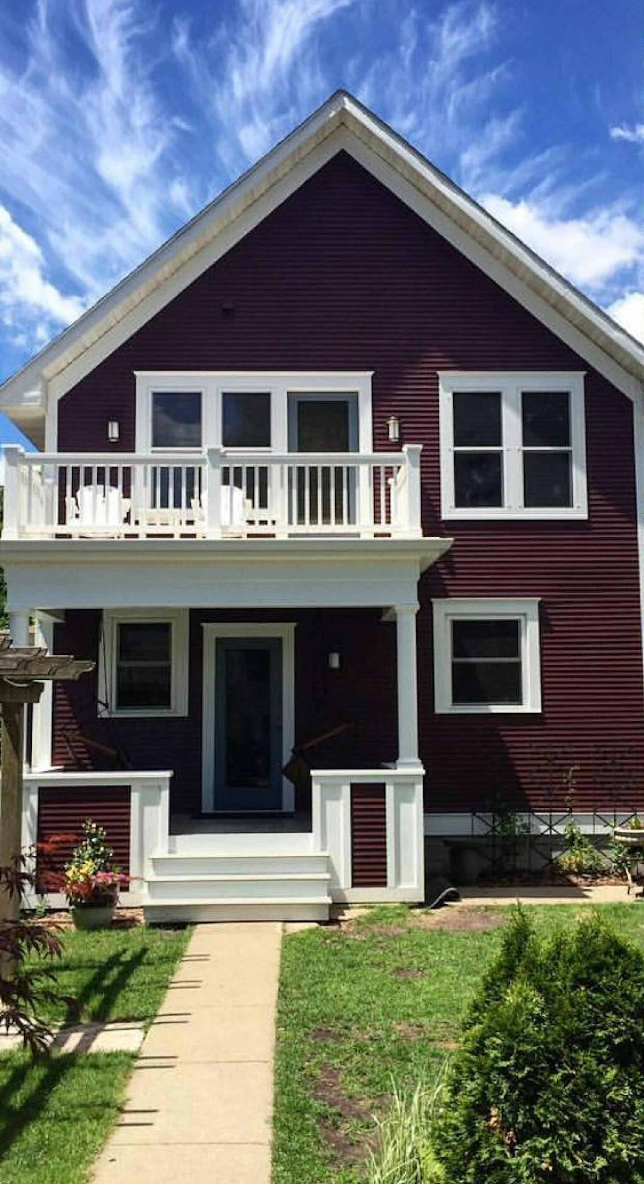 A porch and upper balcony add character and functionality to the back of the 1903 Colonial. The master bedroom steps out to the balcony for more outdoor sitting space. The exterior's deep purple-red paint color "makes the white trim pop," said homeowner David Nathan.