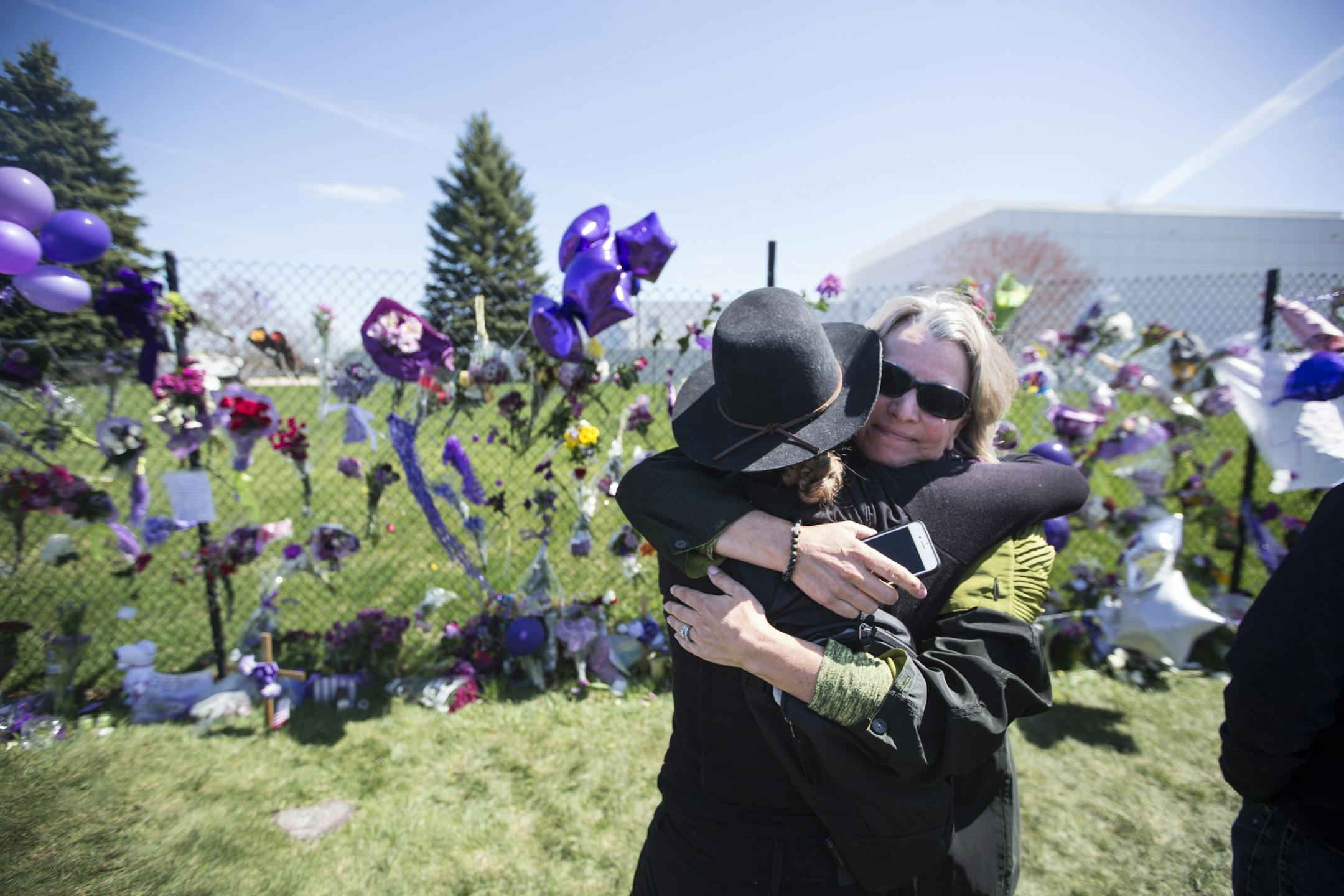 "I don't know you but would you like a hug?" said Laura Masi to Brit Stephens (in hat) as she cried at the memorial set up for Prince at Paisley Park on Friday, April 22, 2016, in Chanhassen, Minn..