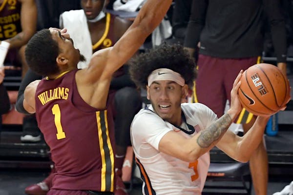 Illinois guard Andre Curbelo (5) puts the ball up as Minnesota's guard Tre' Williams (1) defends in the first half of an NCAA college basketball game 