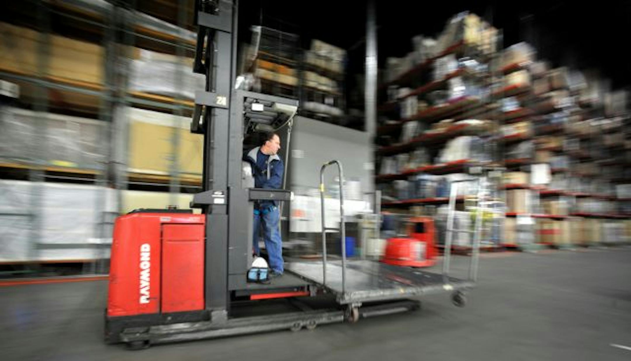 HOM Furniture works to make their warehouse operations extremely efficent. Lights in a warehouse aisle turn on only when an operator is working there. Worker here is Derek Rockow.