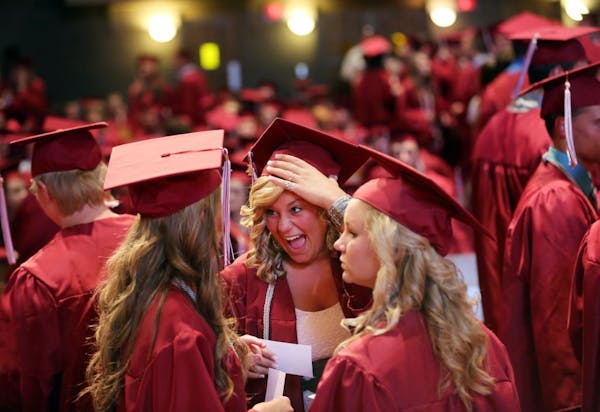Emily Sanden laughed hard as she held on to her cap while chatting before Anoka High's graduation ceremony Tuesday night.