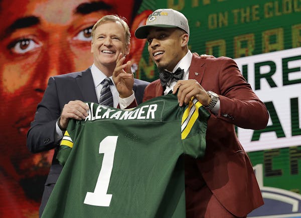 Commissioner Roger Goodell, left, presents Louisville's Jaire Alexander with his Green Bay Packers jersey during the first round of the NFL football d