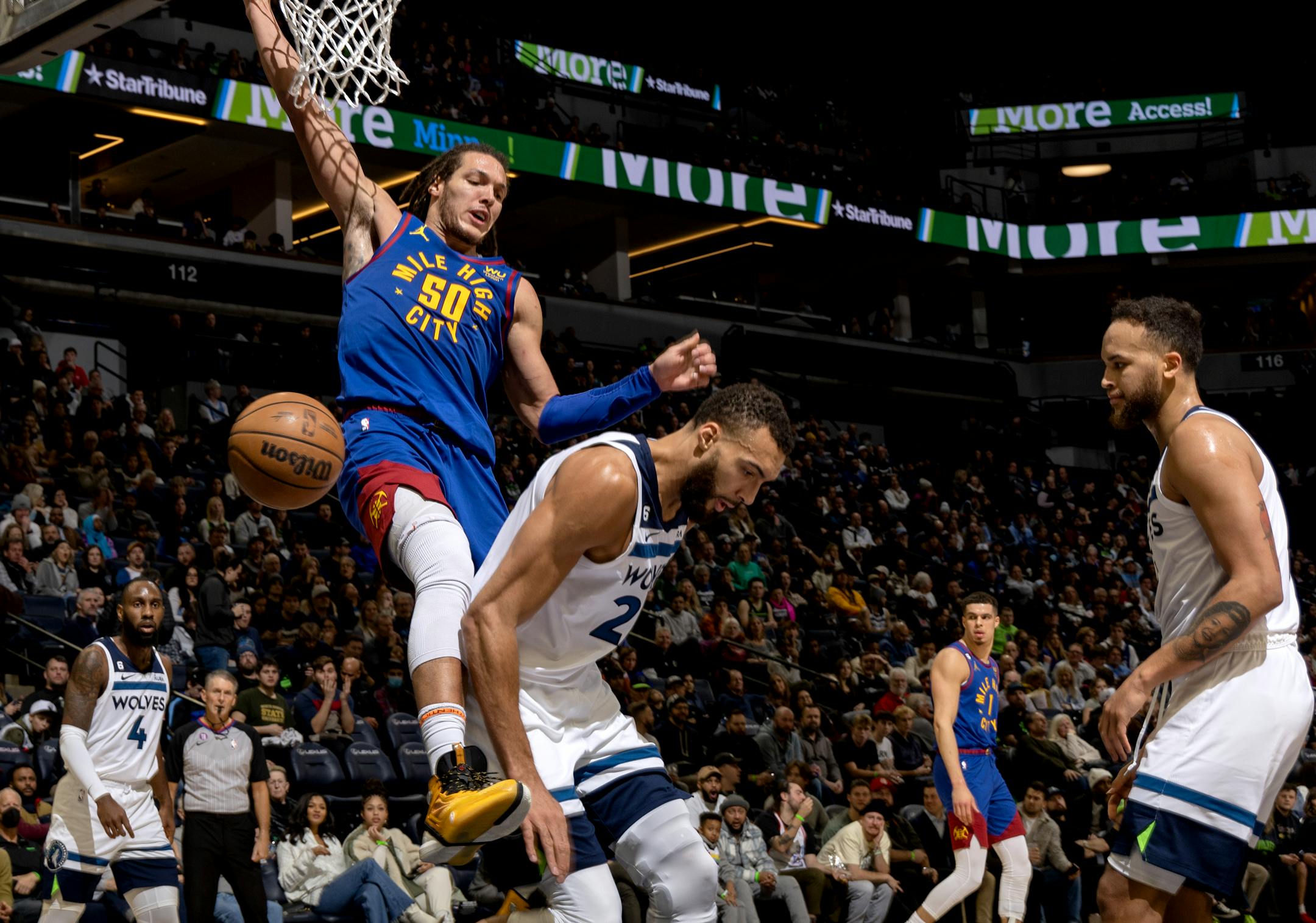 Aaron Gordon (50) of the Denver Nuggets dunks the ball next to Rudy Gobert (27) of the Minnesota Timberwolves in the third quarter.