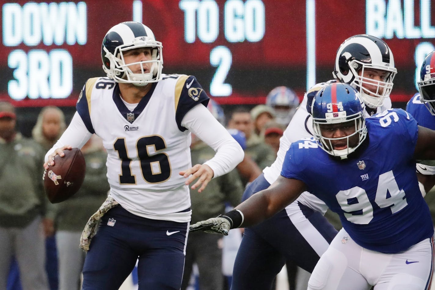 Los Angeles Rams' Jared Goff (16) looks to pass during the first half of an NFL football game as New York Giants' Dalvin Tomlinson (94) closes in Sunday, Nov. 5, 2017, in East Rutherford, N.J. Goff threw a pass for a touchdown to Tyler Higbee on the play. (AP Photo/Julio Cortez)