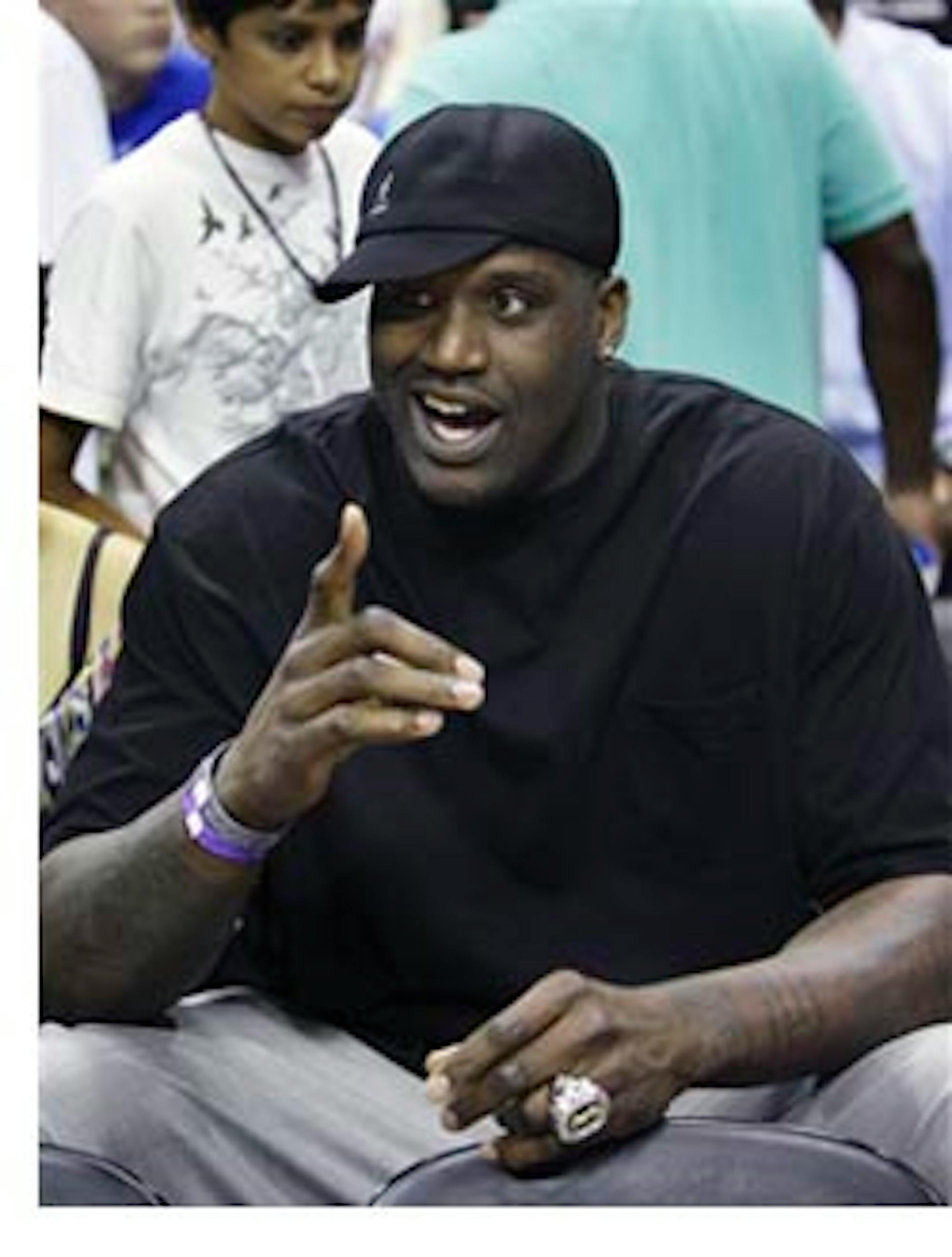 FILE - In this May 26, 2009, file photo, Phoenix Suns center Shaquille O'Neal points to members of the Cleveland Cavaliers before Game 4 of the NBA Eastern Conference basketball finals between the Cavaliers and the Orlando Magic in Orlando, Fla. Even though he hasn't played a game for any team in two months, the NBA Finals has been played in Shaq's shadow, with the center's enormous footprints all over it. (AP Photo/John Raoux, File)