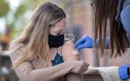 Dr. Kelsey Echols placed a Band-Aid on Roxanne Poplar, 26, of Minneapolis after administering a Covid-19 vaccine shot at Lake Monster Brewing in St. P