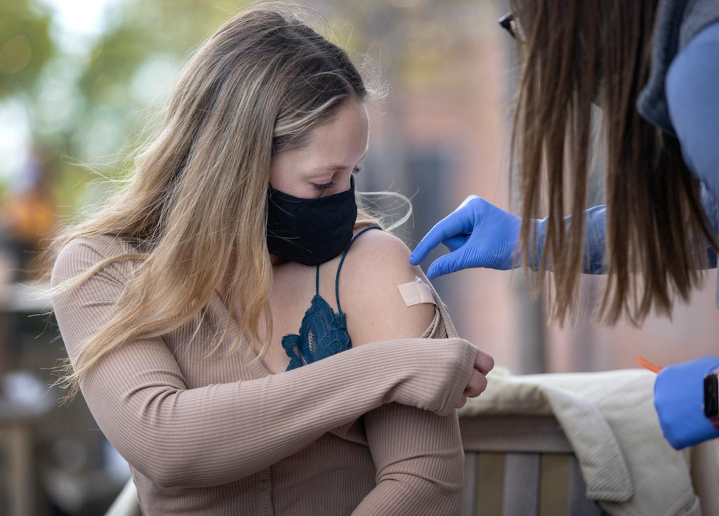 Dr. Kelsey Echols placed a Band-Aid on Roxanne Poplar, 26, of Minneapolis after administering a Covid-19 vaccine shot at Lake Monster Brewing in St. Paul. Dr. Echols helped organize the event with Lake Monster which promoted a free beer coupon after getting the vaccine.