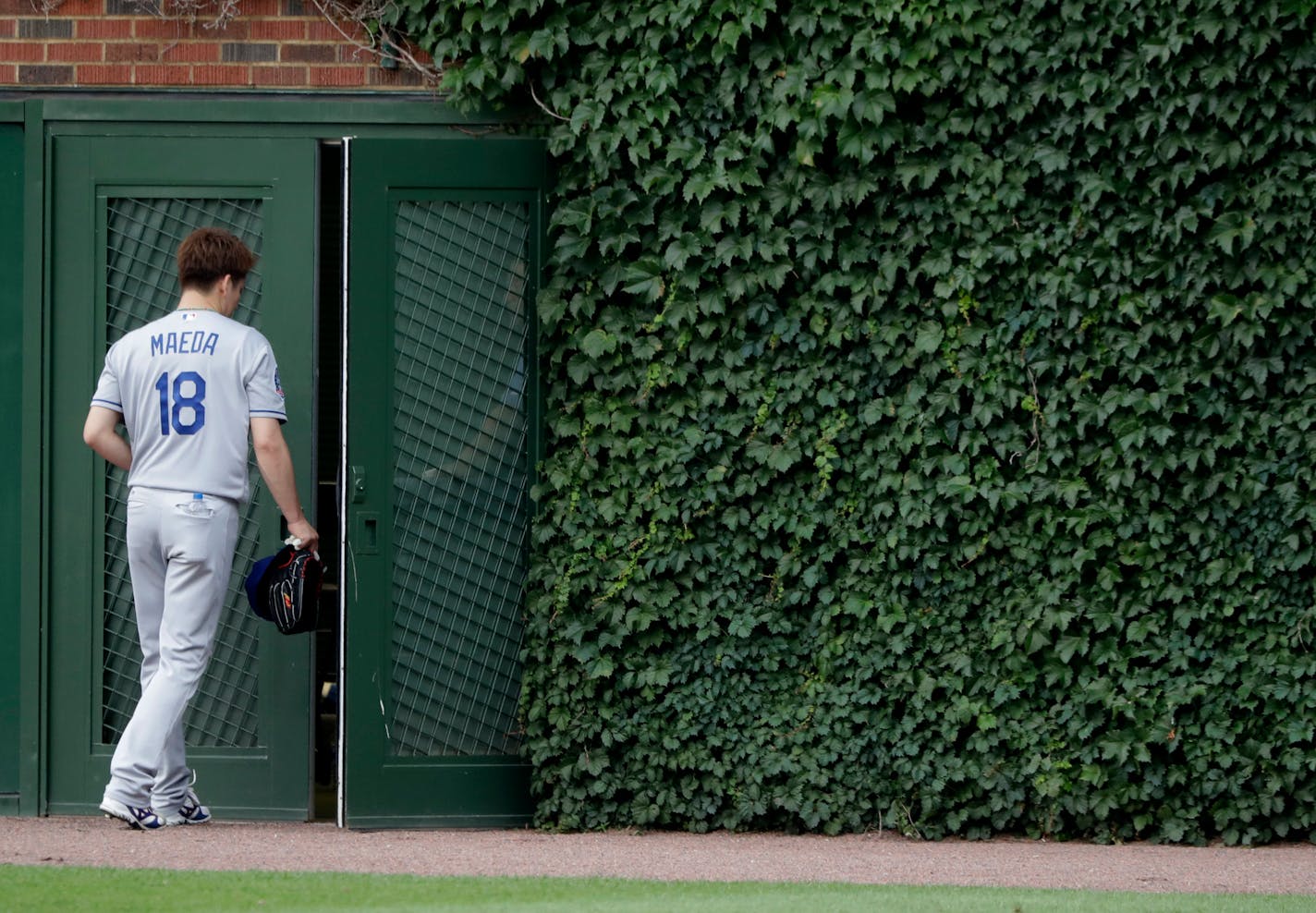 Los Angeles Dodgers starting pitcher Kenta Maeda heads into the bull pen before the start of a rain delayed baseball game between the Chicago Cubs and Dodgers Monday, June 18, 2018, in Chicago. (AP Photo/Charles Rex Arbogast)