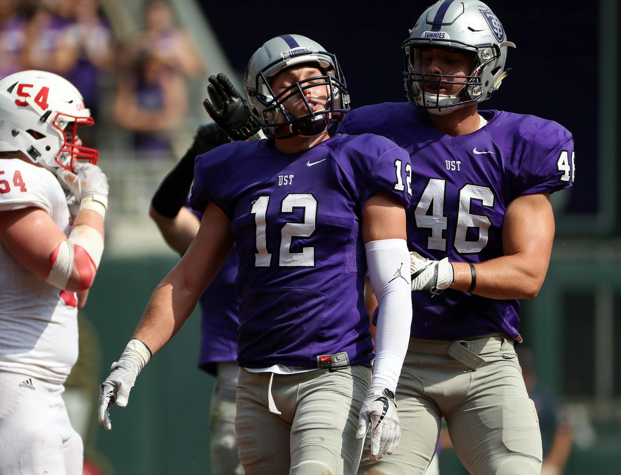 University of St. Thomas linebacker Dylan Andrew (12) was congratulated by University of St. Thomas defensive end Jake LeVahn (46) after making a quarterback sack in the first half. ] ANTHONY SOUFFLE ï anthony.souffle@startribune.com Game action from an NCAA football game between the University of St. Thomas and St. John's University Saturday, Sept. 23, 2017 at Target Field in Minneapolis.