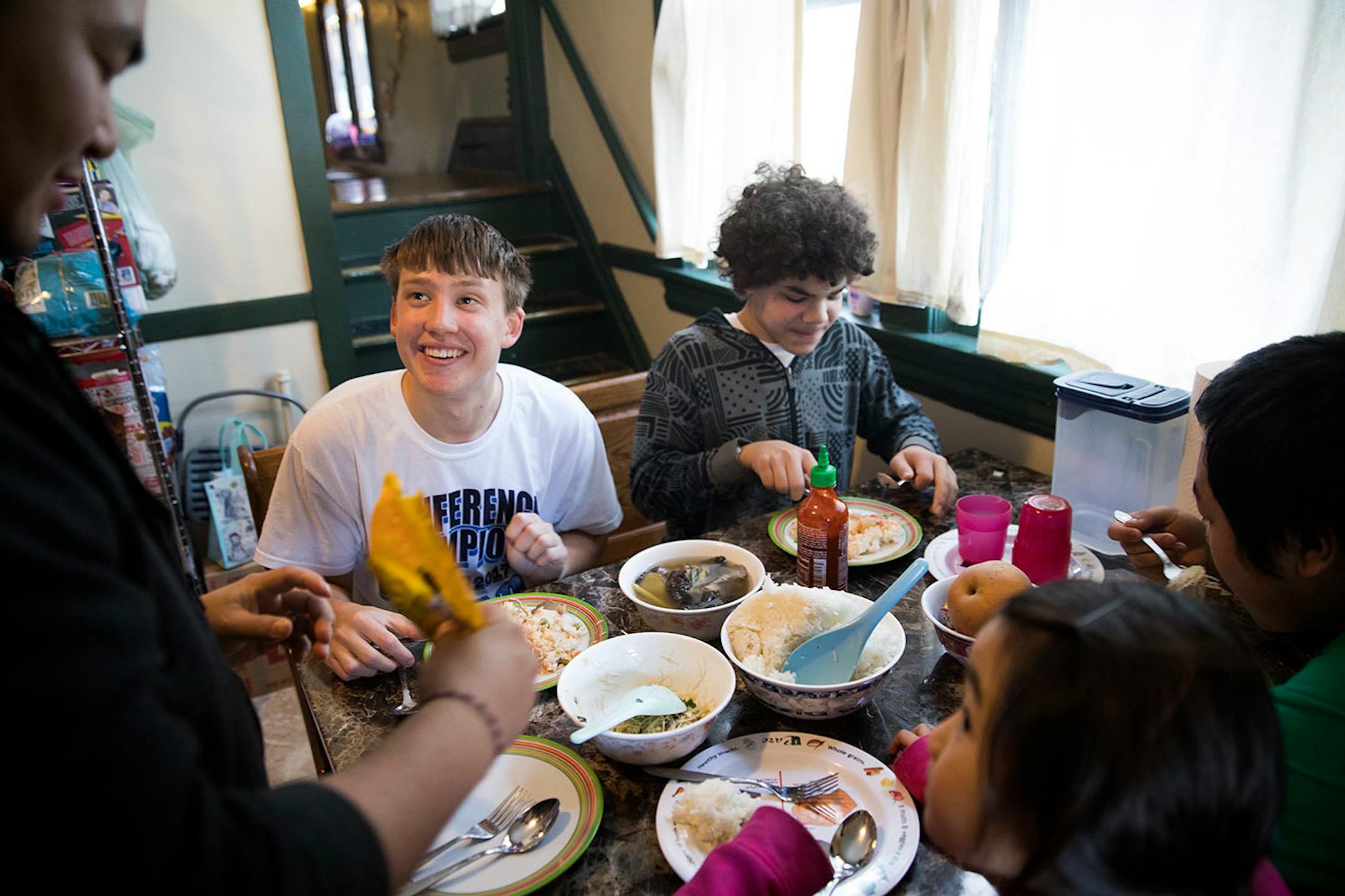 Minnehaha Academy students Peter Shaffer, left, 14, and Daniel Rose, right, 14, eat a traditional Hmong meal that they helped to cook while staying at a Hmong home in St. Paul. ] LEILA NAVIDI ï leila.navidi@startribune.com BACKGROUND INFORMATION: in St Paul on Wednesday, March 15, 2017. City Stay is an opportunity for Minnesota high school students to do home stays at the homes of other local residents. The cultural exchange program fosters new relationships among Minnesota's European, Latin Ame