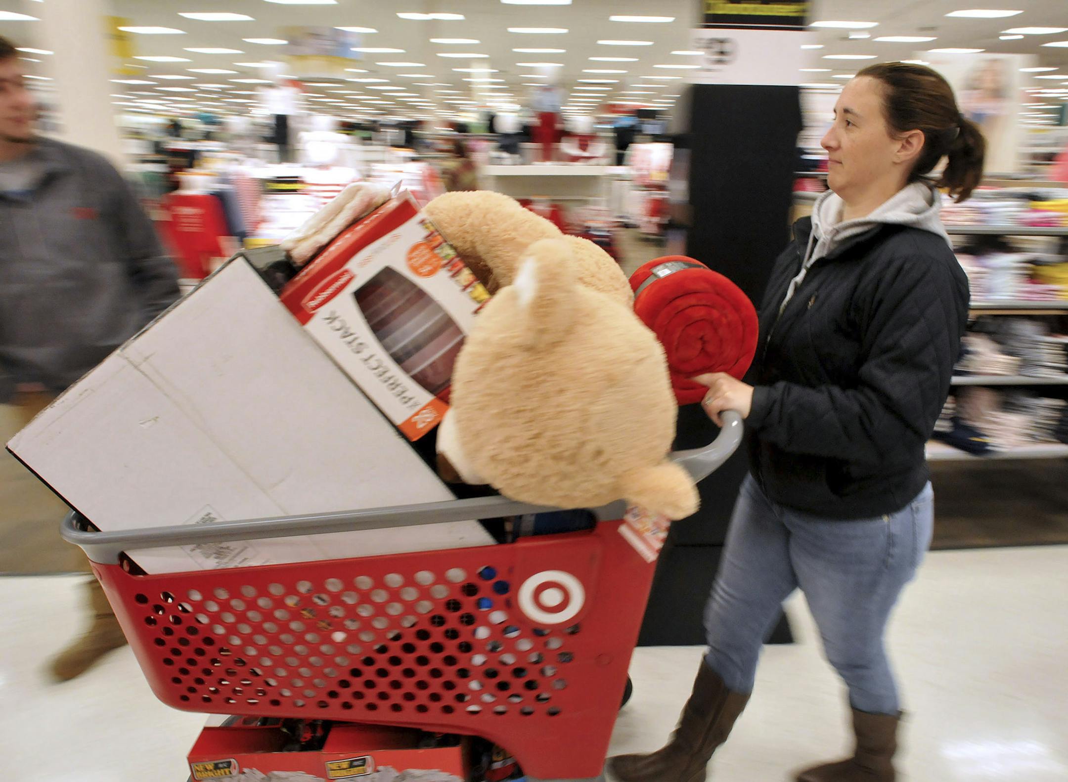A woman pushes her shopping cart on Black Friday at a Target store in Plainville, Mass., Friday, Nov. 23, 2018. (Mark Stockwell/The Sun Chronicle via AP)