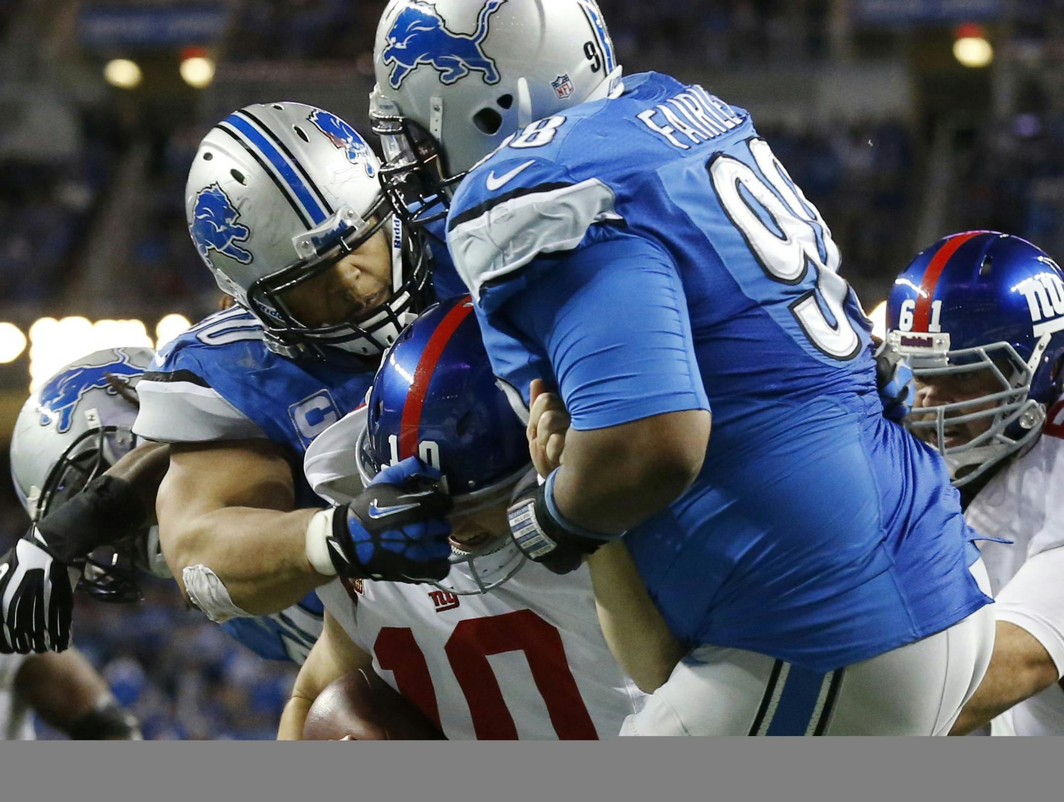 Detroit Lions defensive tackle Ndamukong Suh, rear, and defensive tackle Nick Fairley (98) sack New York Giants quarterback Eli Manning (10) in the end zone for a safety during the third quarter of an NFL football game in Detroit, Sunday, Dec. 22, 2013. (AP Photo/Paul Sancya) ORG XMIT: DTF218