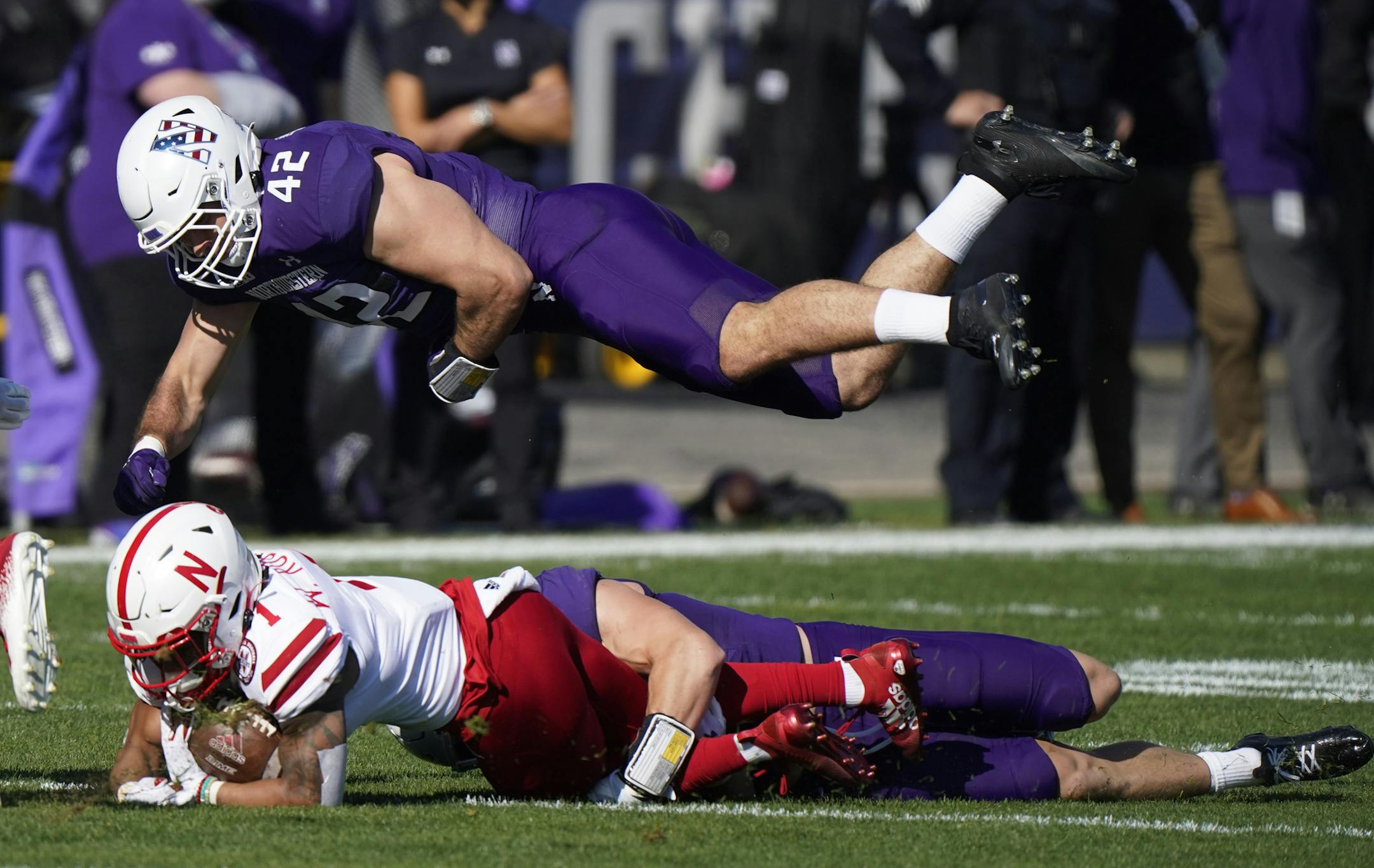 Northwestern linebacker Paddy Fisher, top, jumps for tackle to Nebraska wide receiver Wan'dale Robinson during the first half of an NCAA college football game in Evanston, Ill., Saturday, Nov. 7, 2020. (AP Photo/Nam Y. Huh)