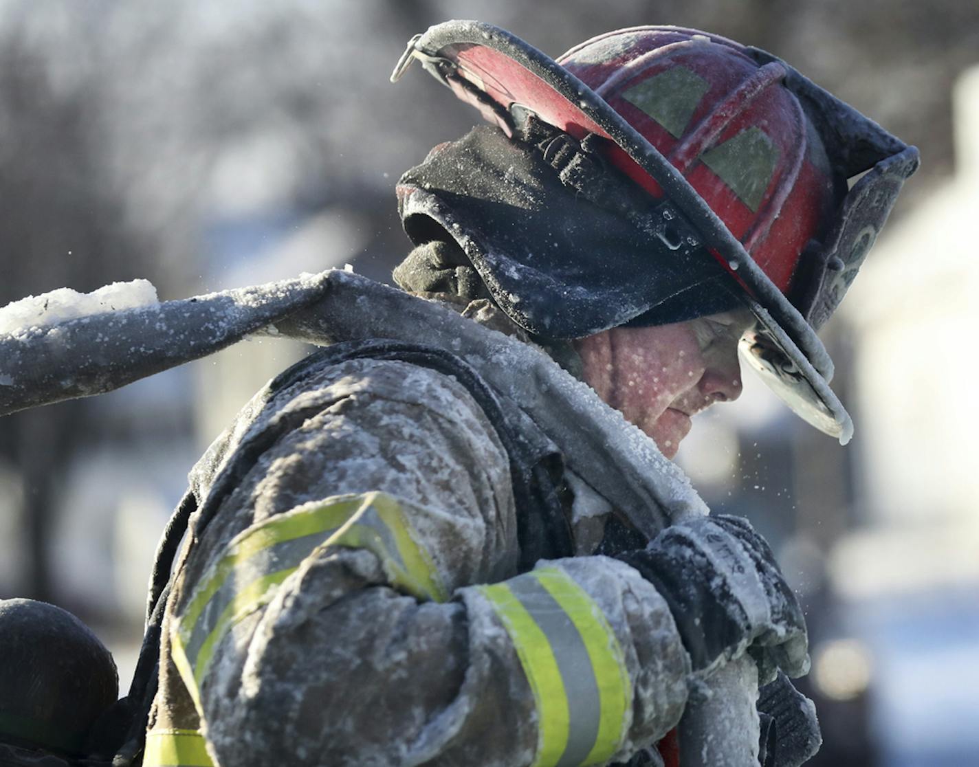 A St. Paul firefighter works at the scene of a house fire Wednesday, Jan. 30, 2019, In St. Paul, Minn. (David Joles/Star Tribune via AP)