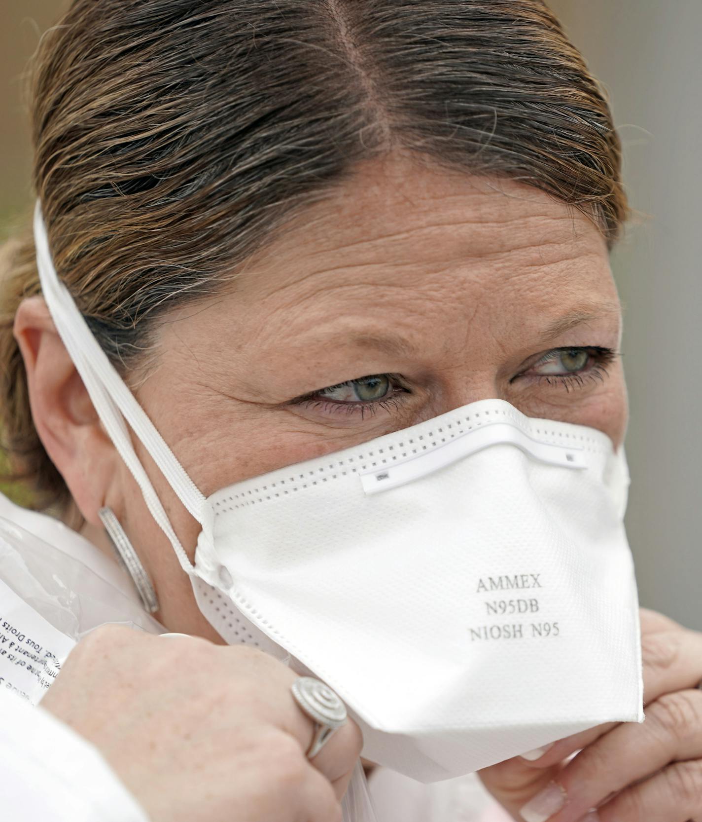 Nurse Yvette Laugere adjusts her N95 mask while working at a newly opened free Covid-19 testing site operated by United Memorial Medical Center Thursday, April 2, 2020, in Houston. The new coronavirus causes mild or moderate symptoms for most people, but for some, especially older adults and people with existing health problems, it can cause more severe illness or death. (AP Photo/David J. Phillip)