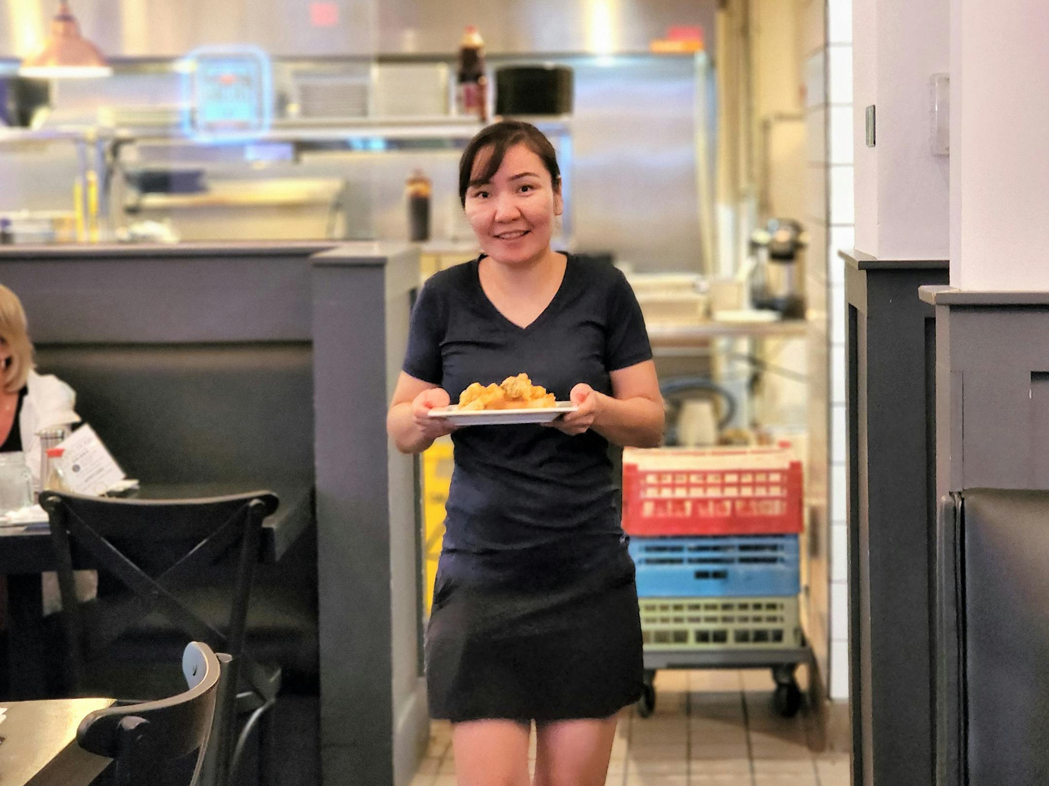 Kazoku co-owner Uzmee Uilsdelger delivers a dish from the kitchen.