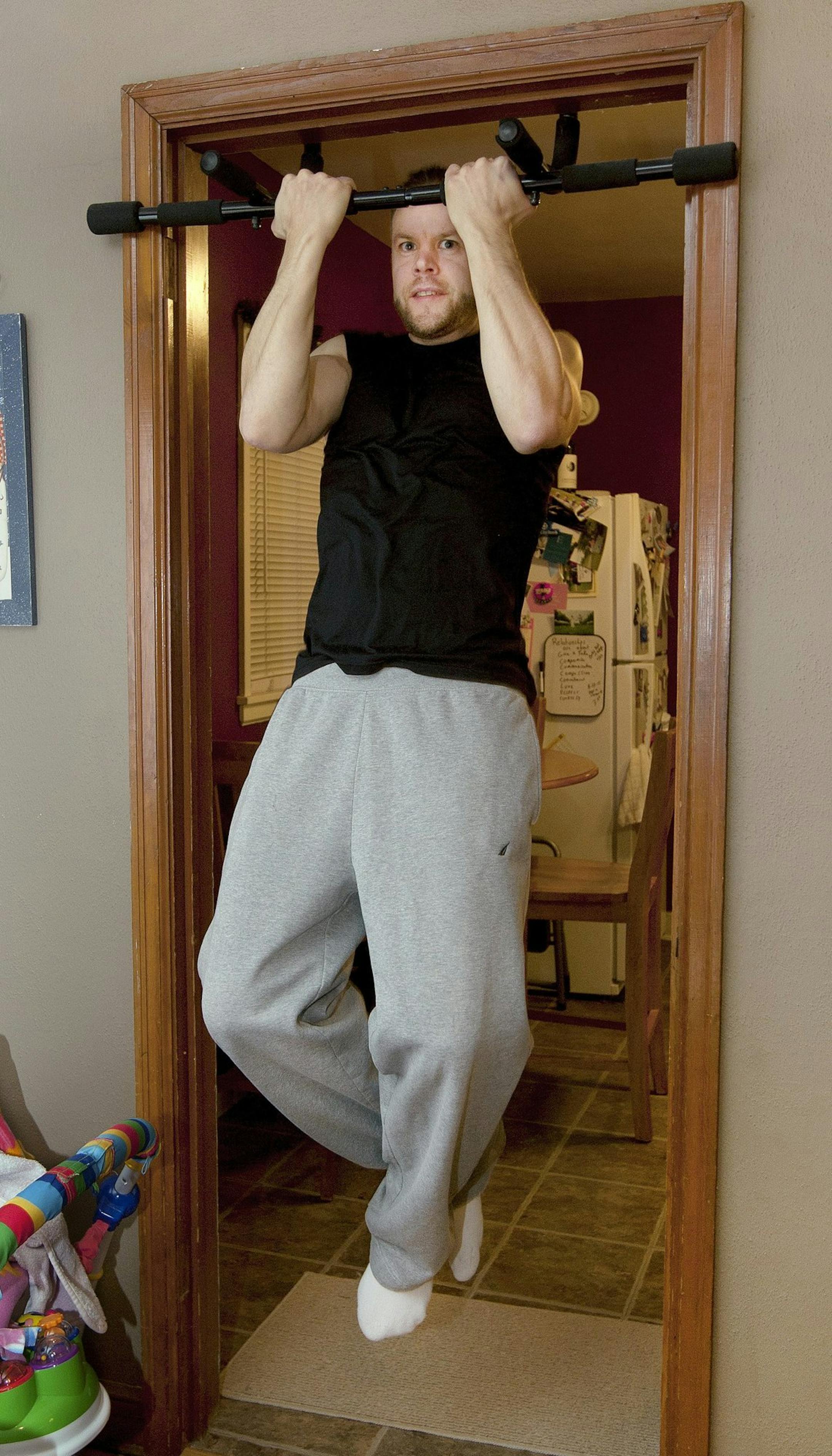 Kevin Praska does pull-ups at his Grand Forks, N.D. home, Nov. 26, 2013, and still practices aspects of P90DX as well as exercising at a fitness center to maintain his current weight of 175 pounds. (John Stennes/Grand Forks Herald/MCT) ORG XMIT: 1146633