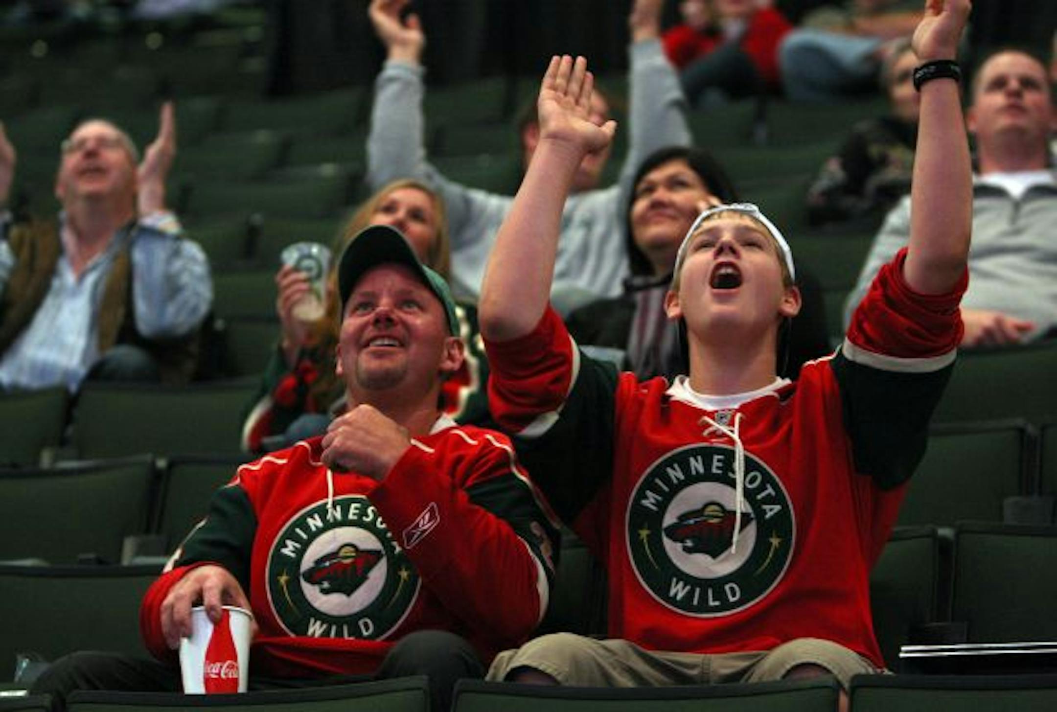 Bob Glick and his son Alex, 12, of Coon Rapids cheered for the Twins as they watched Tuesday's AL Central tiebreaker on the Xcel Energy Center big screen before the home opener.