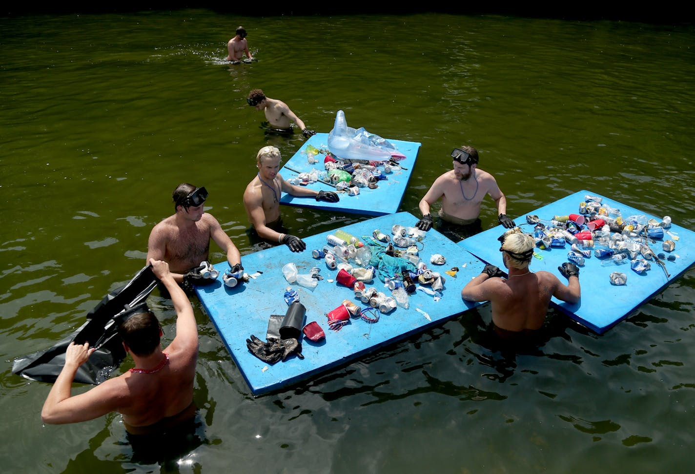 The Lake Minnetonka Association, in partnership with Life�s a Beach Shoreline Services and Tonka Bay Marina, as well as some lake homeowners did their annual trash sweep, cleaning up trash left behind near Big Island left by the hundreds of boaters and fun seekers on July 4 and seen Wednesday, July 5, 2017, in Tonka Bay, MN. Here, Life�s a Beach Shoreline Services workers bag trash they collected in and around Lake Minnetonka's Big Island before the trash was hauled out by a barge from Tonka Bay