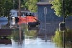 Water rises to a moose statue in flooded Cook, Minn., on Wednesday night.
