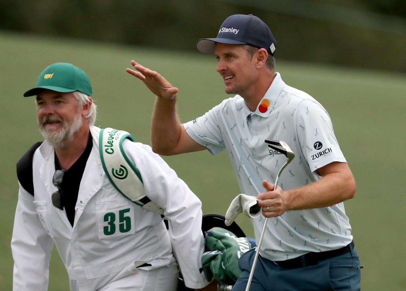 Justin Rose and his caddie David Clark react to his second shot on the eighteenth hole during the first round of the Masters golf tournament at Augusta National Golf Club, Thursday, April 8, 2021, in Augusta, Ga. (Curtis Compton/Atlanta Journal-Constitution via AP)