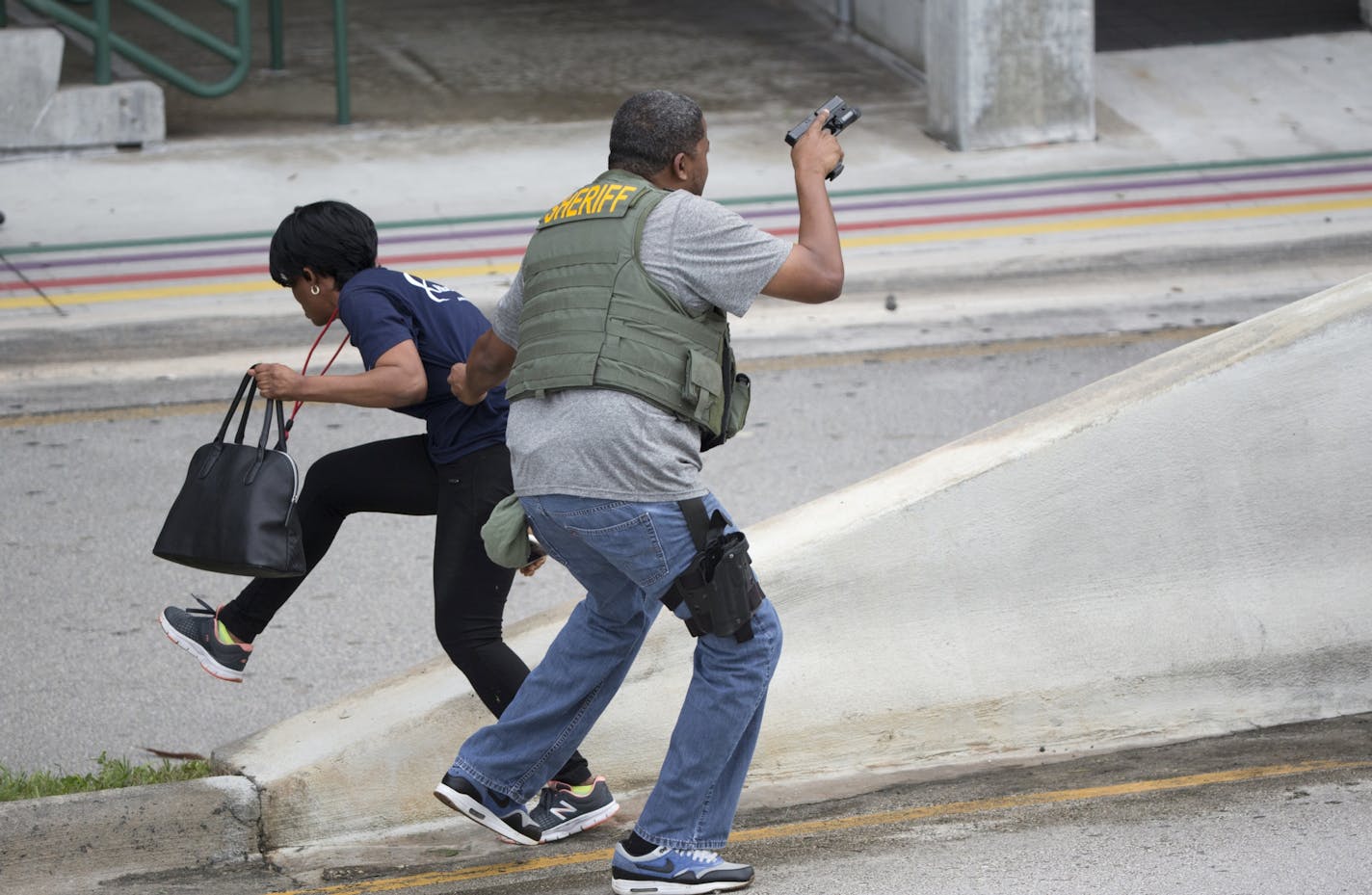 A law enforcement officer evacuates a civilian from an area at Fort Lauderdale-Hollywood International Airport, Friday, Jan. 6, 2017, in Fort Lauderdale, Fla.