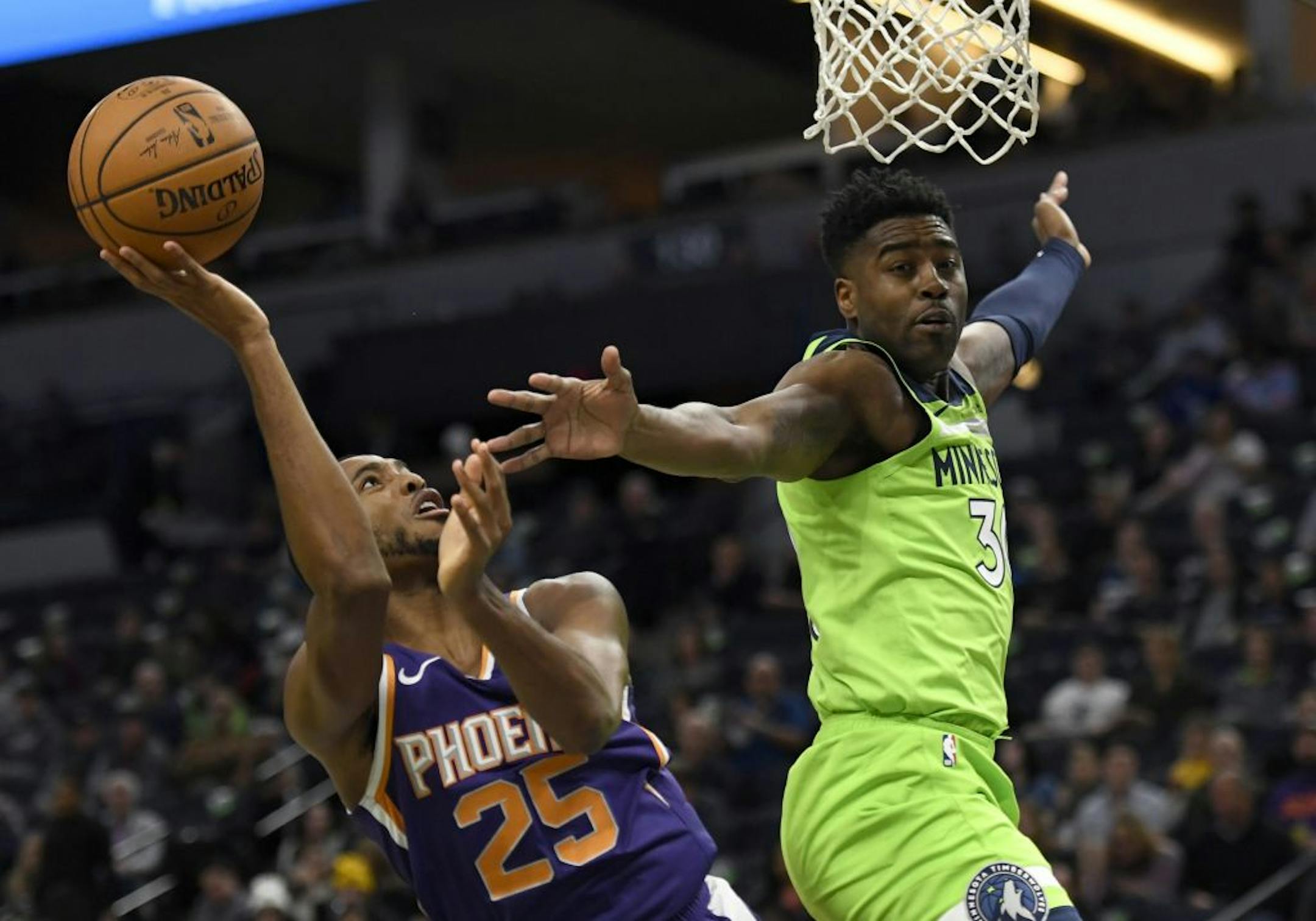 Phoenix Suns' Mikal Bridges (25) is fouled by Minnesota Timberwolves' Kelan Martin (30) while shooting during the first quarter of an NBA basketball game on Saturday, Nov. 23, 2019, in Minneapolis.