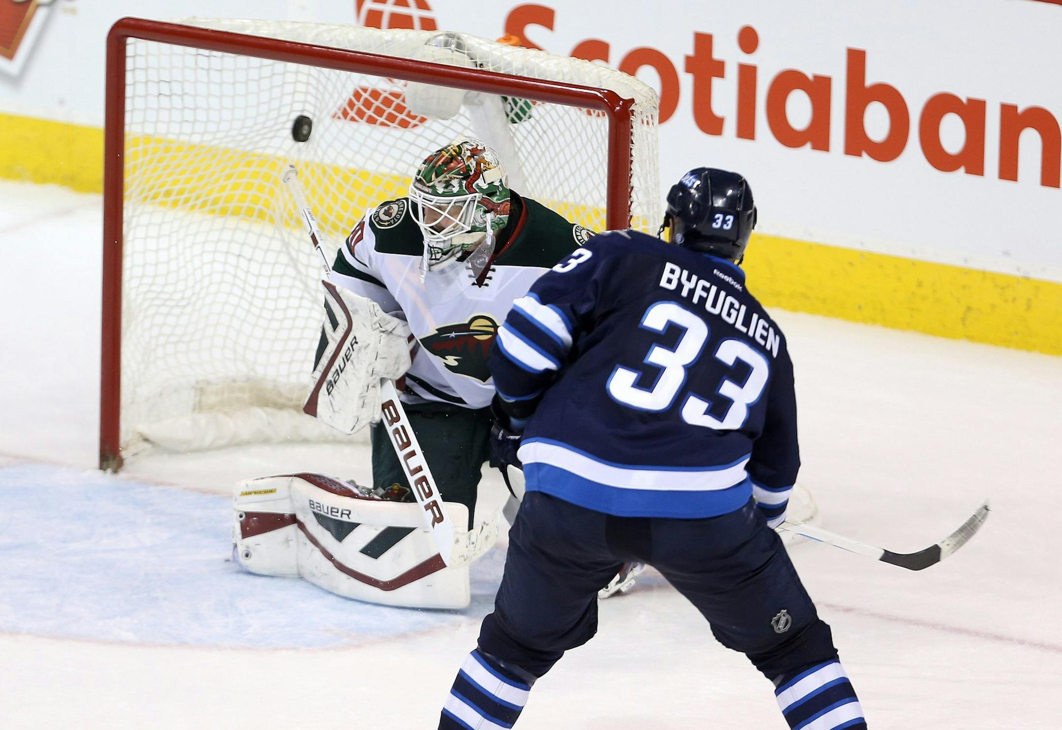 Winnipeg Jets' Dustin Byfuglien (33) scores against Minnesota Wild goaltender Devan Dubnyk (40) during overtime in an NHL hockey game Tuesday, Feb. 10, 2015, in Winnipeg, Manitoba. The Jets won 2-1. (AP Photo/The Canadian Press, Trevor Hagan)