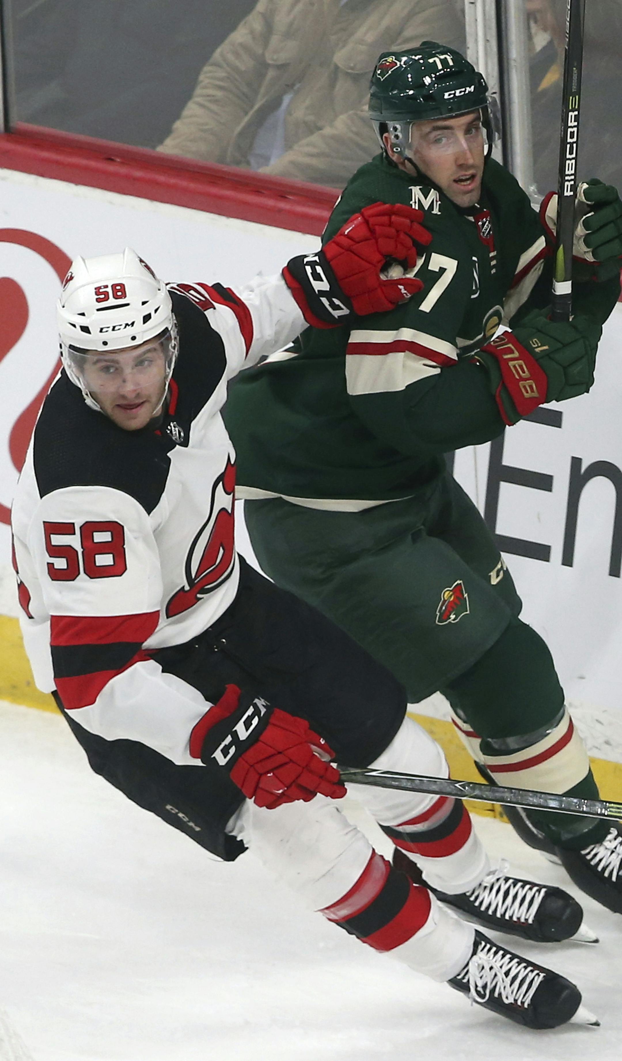 New Jersey Devils' Kevin Rooney, left, pushes off Minnesota Wild's Brad Hunt in the first period of an NHL hockey game Friday, Feb.15, 2019, in St. Paul, Minn. (AP Photo/Jim Mone)