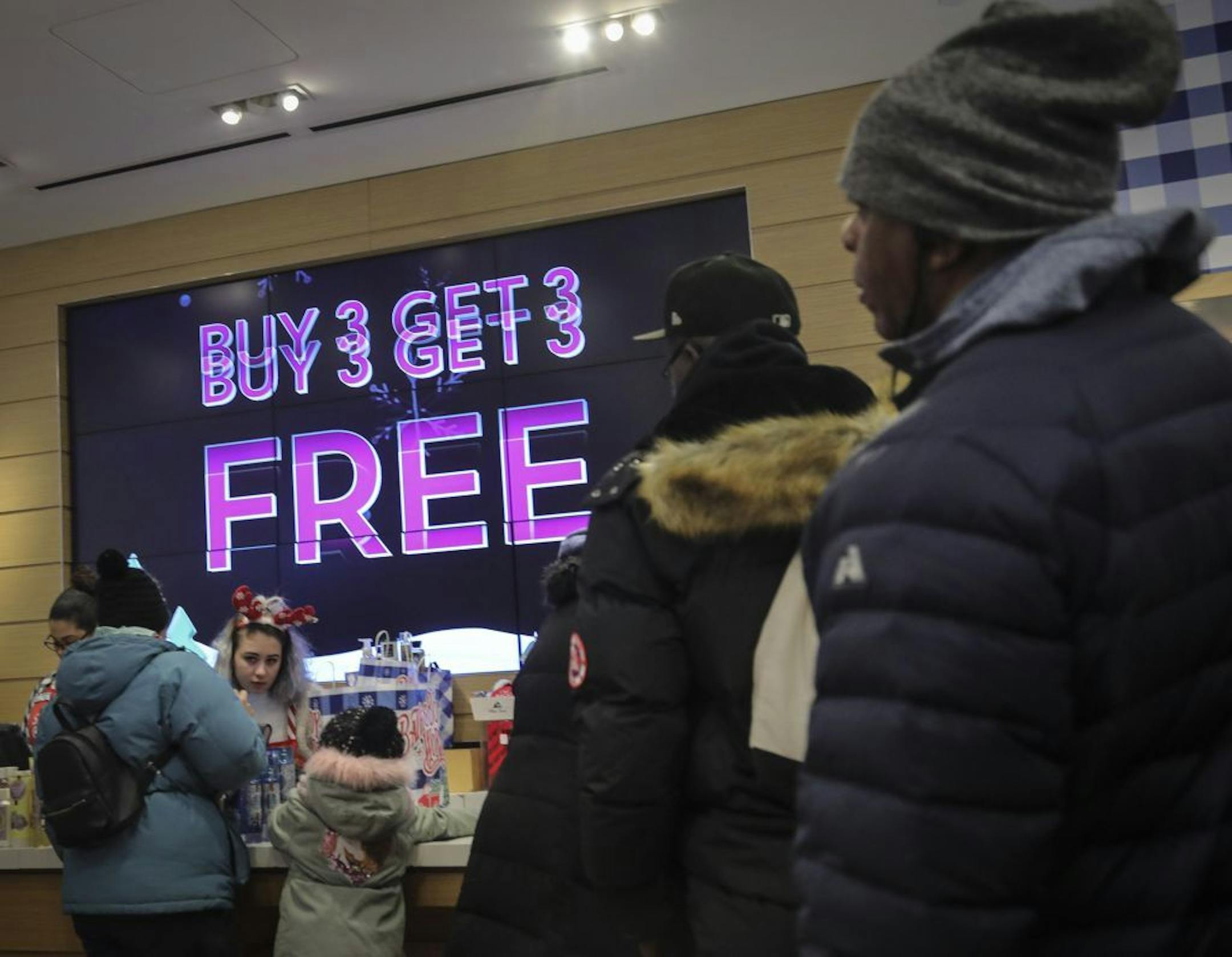 Shoppers stand in line to make Black Friday discount purchases at Bath and Bodyworks, Friday Nov. 29, 2019, in Brooklyn, N.Y. The National Retail Federation, the nation's largest retail trade group, forecasts that holiday sales will rise from the disappointing growth in the November and December 2018.