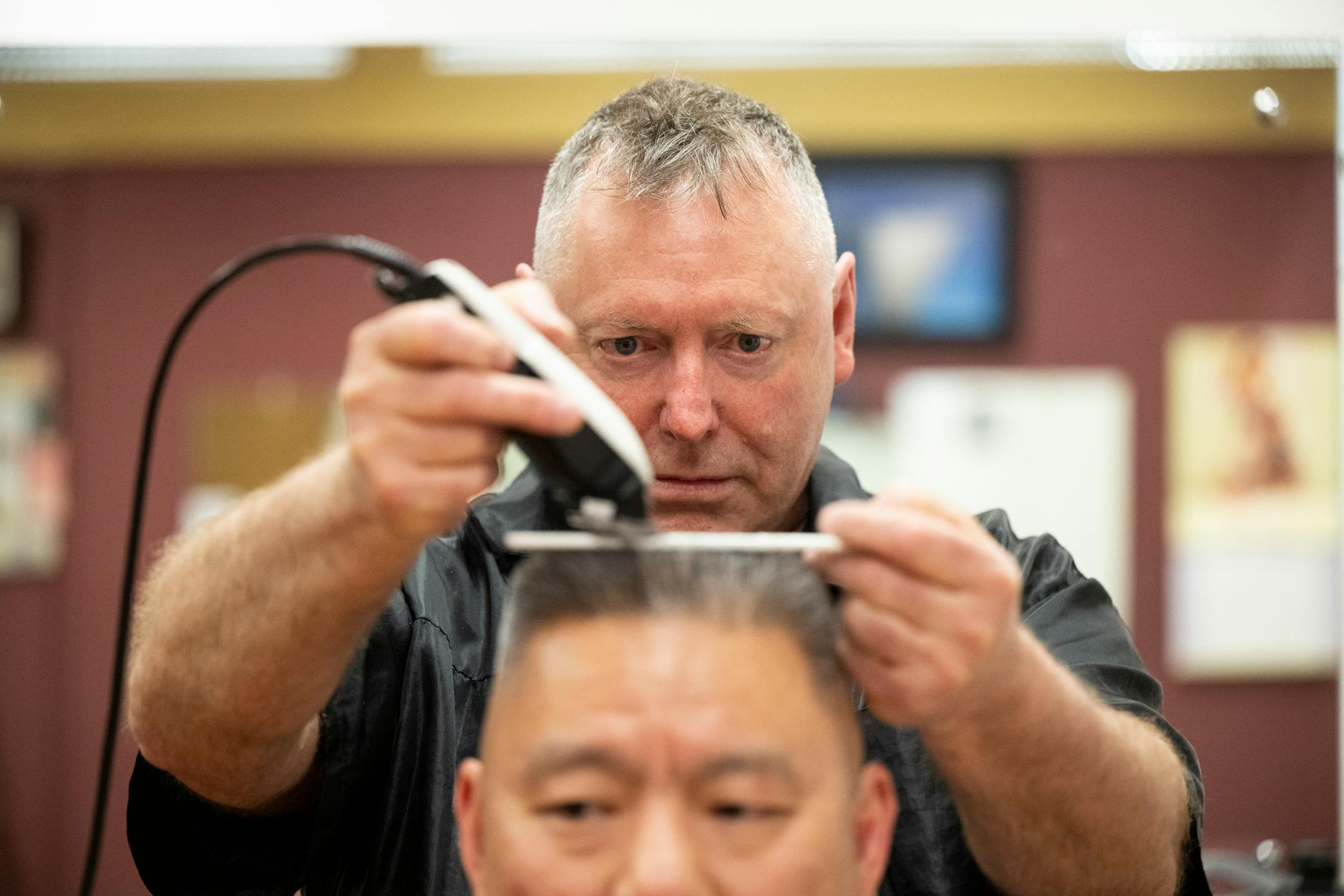 Bob Haddow cuts the hair of longtime client Alan King, a civil litigation and criminal defense attorney, Wednesday, March 29, 2023 at the Grain Exchange Barbershop in Minneapolis, Minn.. Haddow, veteran barber and philosopher at the Grain Exchange Barbershop is out on Friday, thanks to remodeling of the 120-year-old building lobby by the Grain Exchange owner. Haddow, 66, a trained art historian, amateur writer, portrait painter and unvarnished psychologist, has a loyal clientele of lawyers, cops, retired traders and other business people. He's heading to a barber chair at a friend's shop near the Schooner Bar in Seward Neighborhood, where he lives with his physician wife.