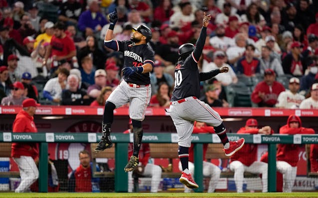 The Twins' Carlos Santana, left, celebrates his three-run home run with third base coach Tommy Watkins during the fourth inning Saturday in Anaheim.