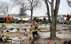 Firefighters sift through the rubble after one person died and another was seriously injured following a house explosion Tuesday, Feb. 5, 209, in the 