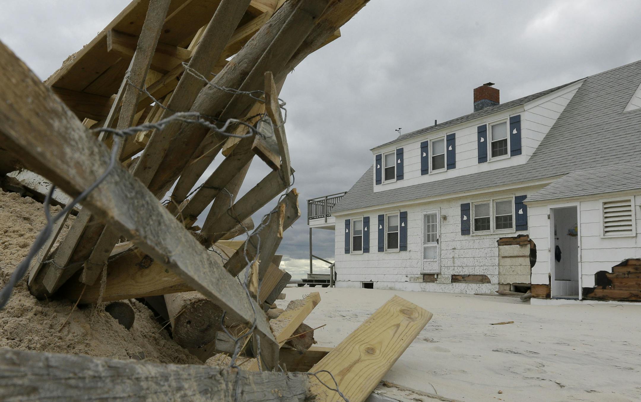 FILE - This Nov. 1, 2012 file photo shows a pile of sand and debris sitting near a house that was damaged by superstorm Sandy in Brant Beach, N.J. A new psychology study shows that people are wrongly less prone to flee from hurricanes with feminine names. Yet the study finds female named storms have been deadlier in the United States than their macho sounding counterparts. Katrina and Sandy are the two deadliest storms to make landfall in the U.S. since names went co-ed in 1979. The study, which