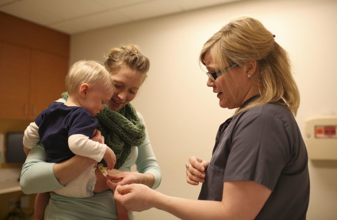 Anna Calcote repositioned a band aid on her son, Weston, 1, after he braved his 12-month series of shots, including the MMR vaccine, at the Children's Specialty Center at Children's Hospital in Minneapolis on Jan. 29, 2015.