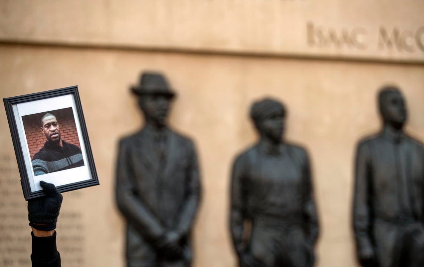 A protestor held up a photo of George Floyd in front of the Clayton, Jackson, McGhie Memorial on May 30 as part of a large protest in Duluth, MN.