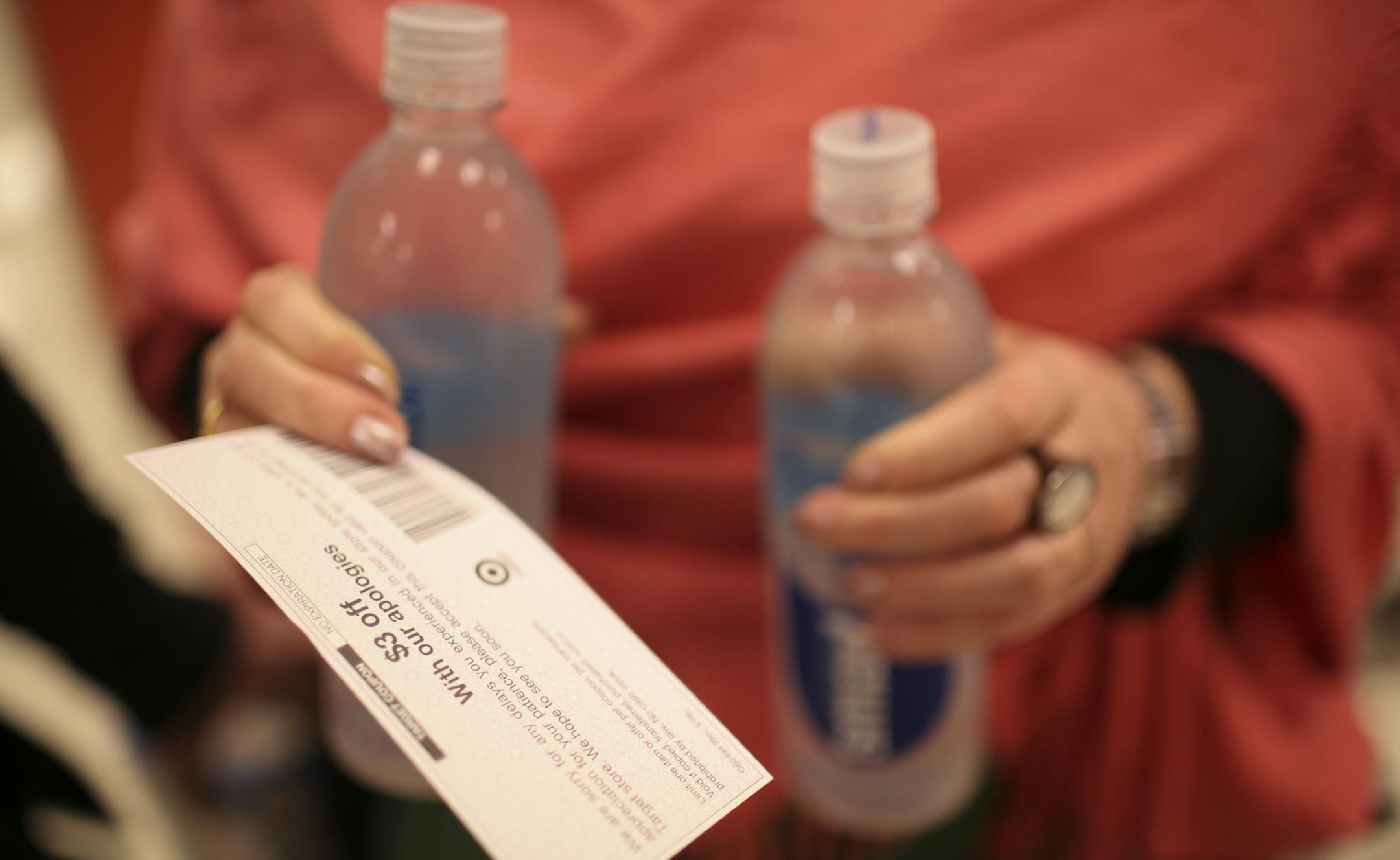 A customer waiting in line held a $3 off coupon and the water she was purchasing at the downtown Minneapolis Target store Sunday night. ] JEFF WHEELER ‚Ä¢ jeff.wheeler@startribune.com A network outage caused checkout delays at Target stores Sunday evening. Managers were handing out $3 coupons and offering cookies to customers as they waited in line to check out. ORG XMIT: MIN1406152046390992