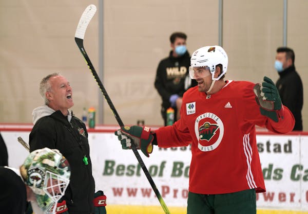Wild coach Dean Evason laughs with Marcus Foligno before a practice this summer ahead of the NHL's restart.