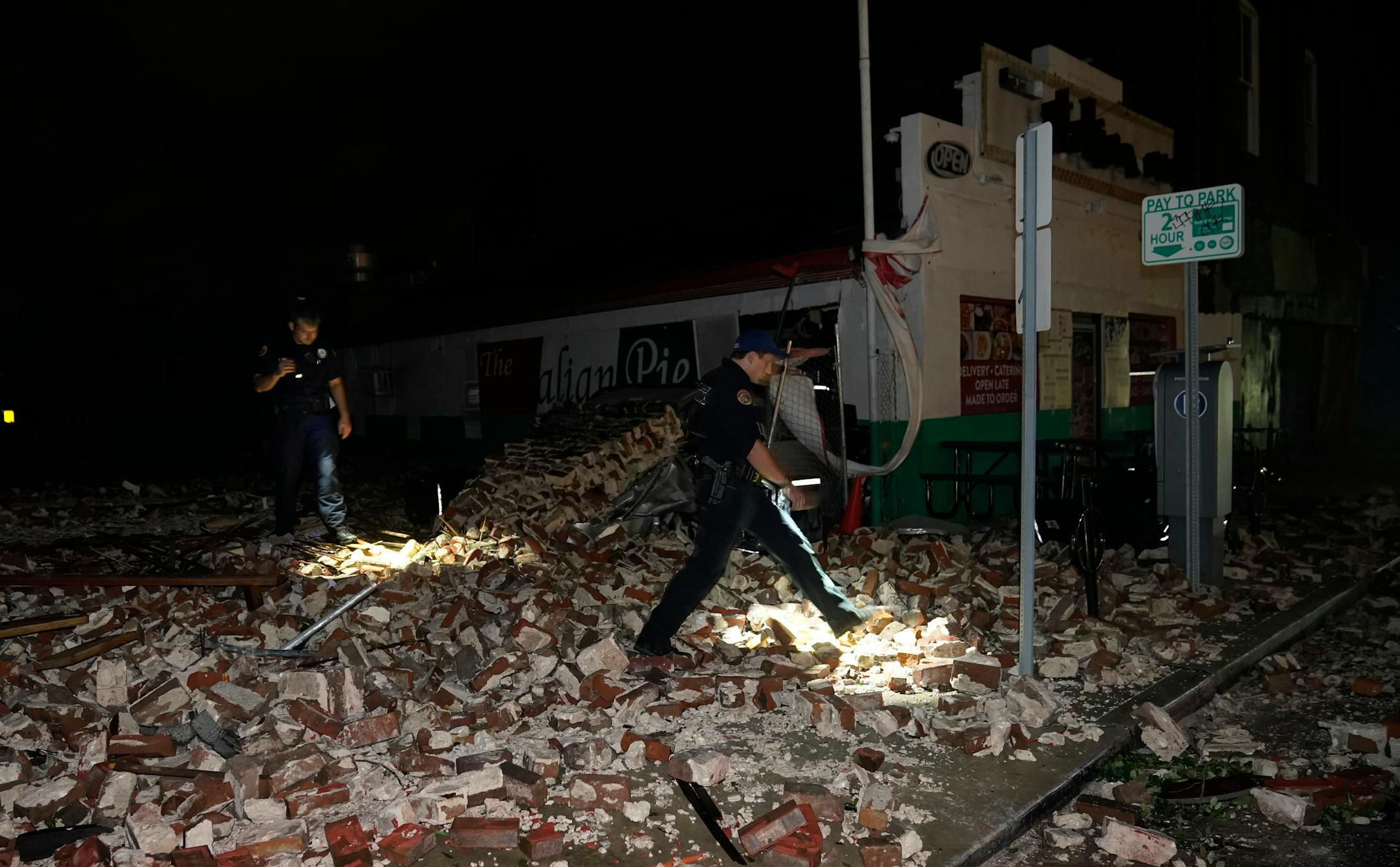 Police look through debris after a building collapsed from the effects of Hurricane Ida, Monday, Aug. 30, 2021, in New Orleans, La. Hurricane Ida knocked out power to all of New Orleans and inundated coastal Louisiana communities on a deadly path through the Gulf Coast that is still unfolding and promises more destruction. (AP Photo/Eric Gay)