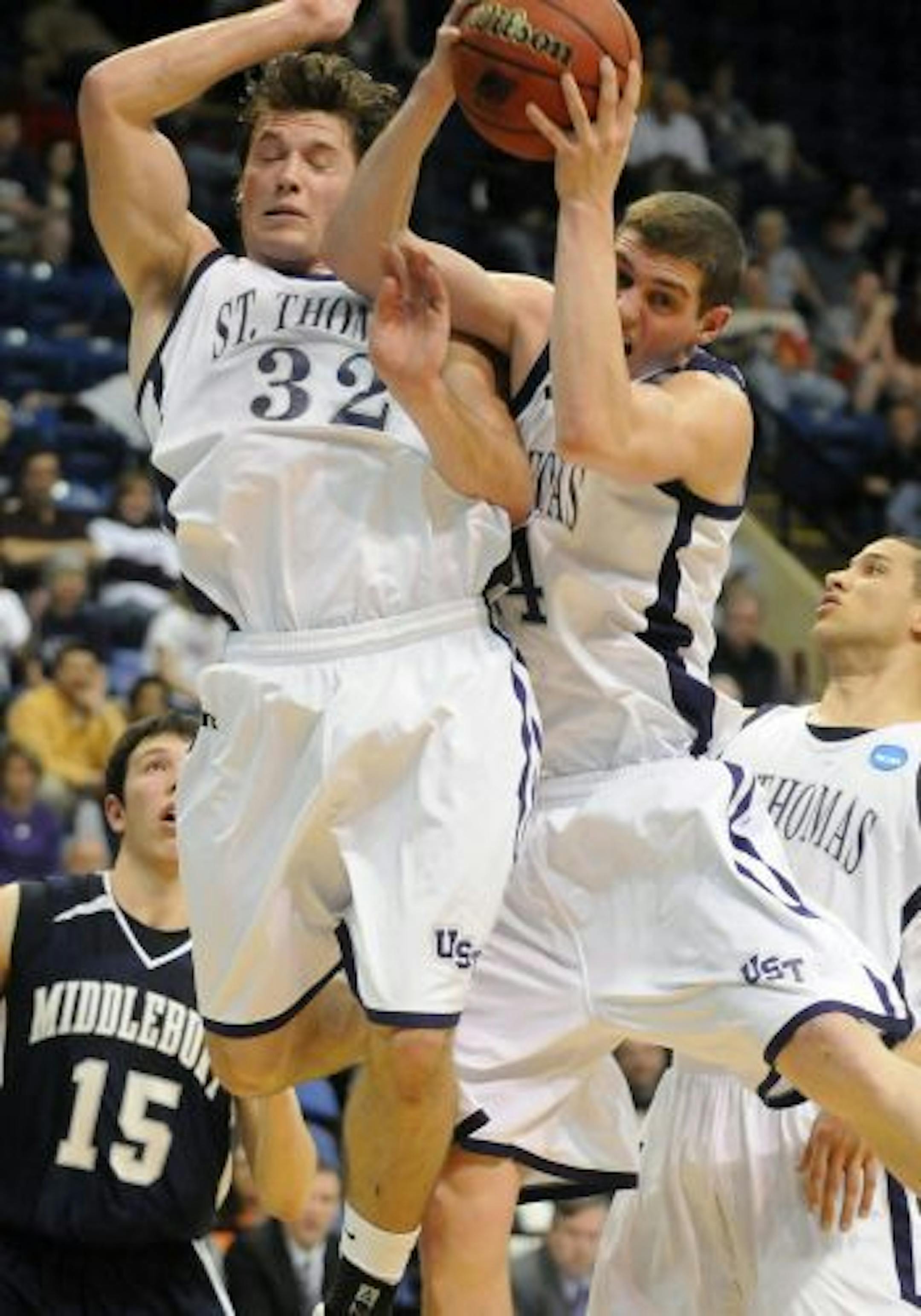 St. Thomas guard Brady Irvin (32) and Tommy Hannon grab a rebound during the first half of an NCAA Division III semifinal college basketball game against Middlebury at the Salem Civic Center in Salem, Va., Friday March 18, 2011.