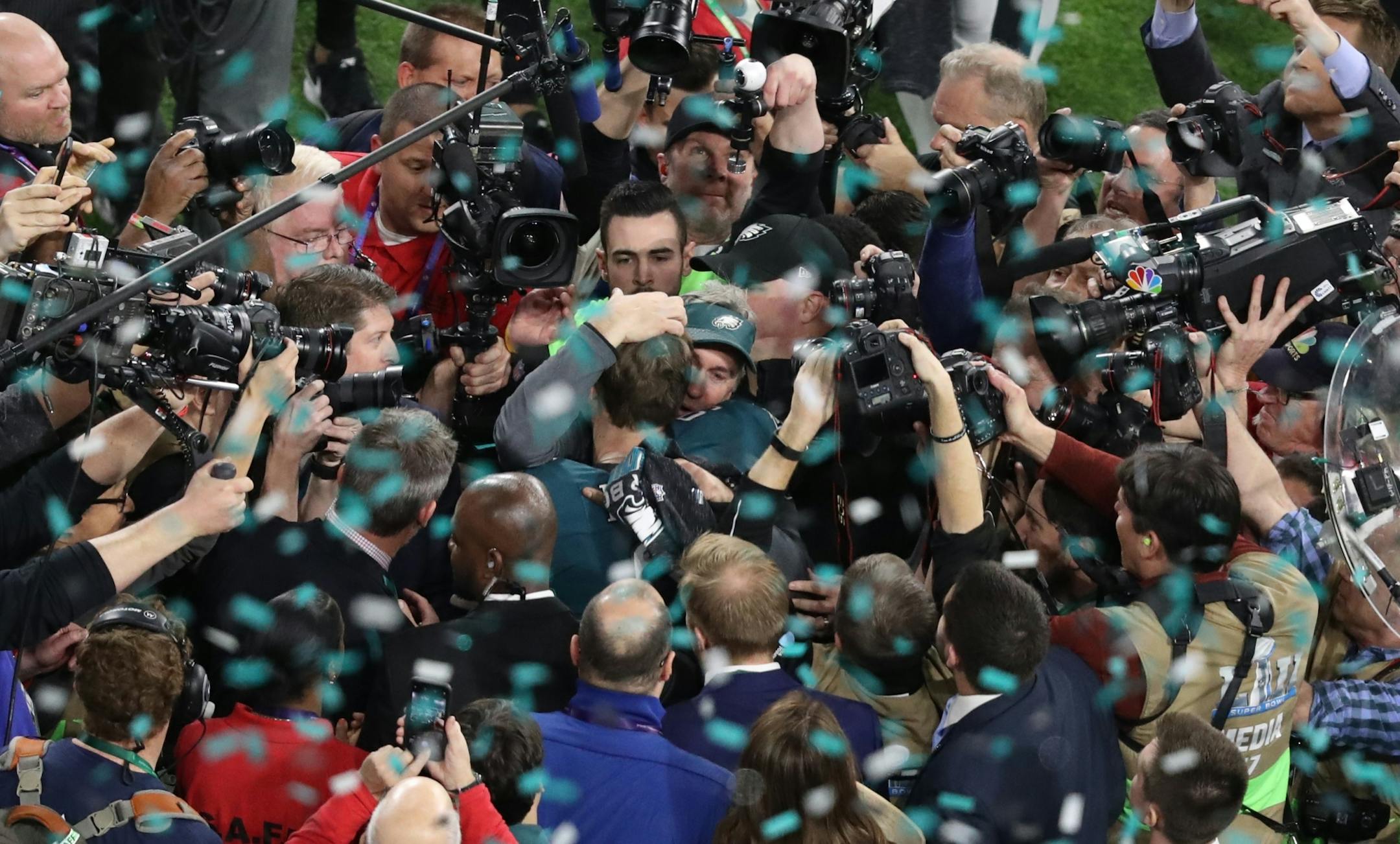 Philadelphia Eagles head coach Doug Pederson, center, in baseball cap, embraced quarterback Nick Foles (9) after winning Super Bowl LII at U.S. Bank Stadium. The Eagles defeated the New England Patriots 41-33.
