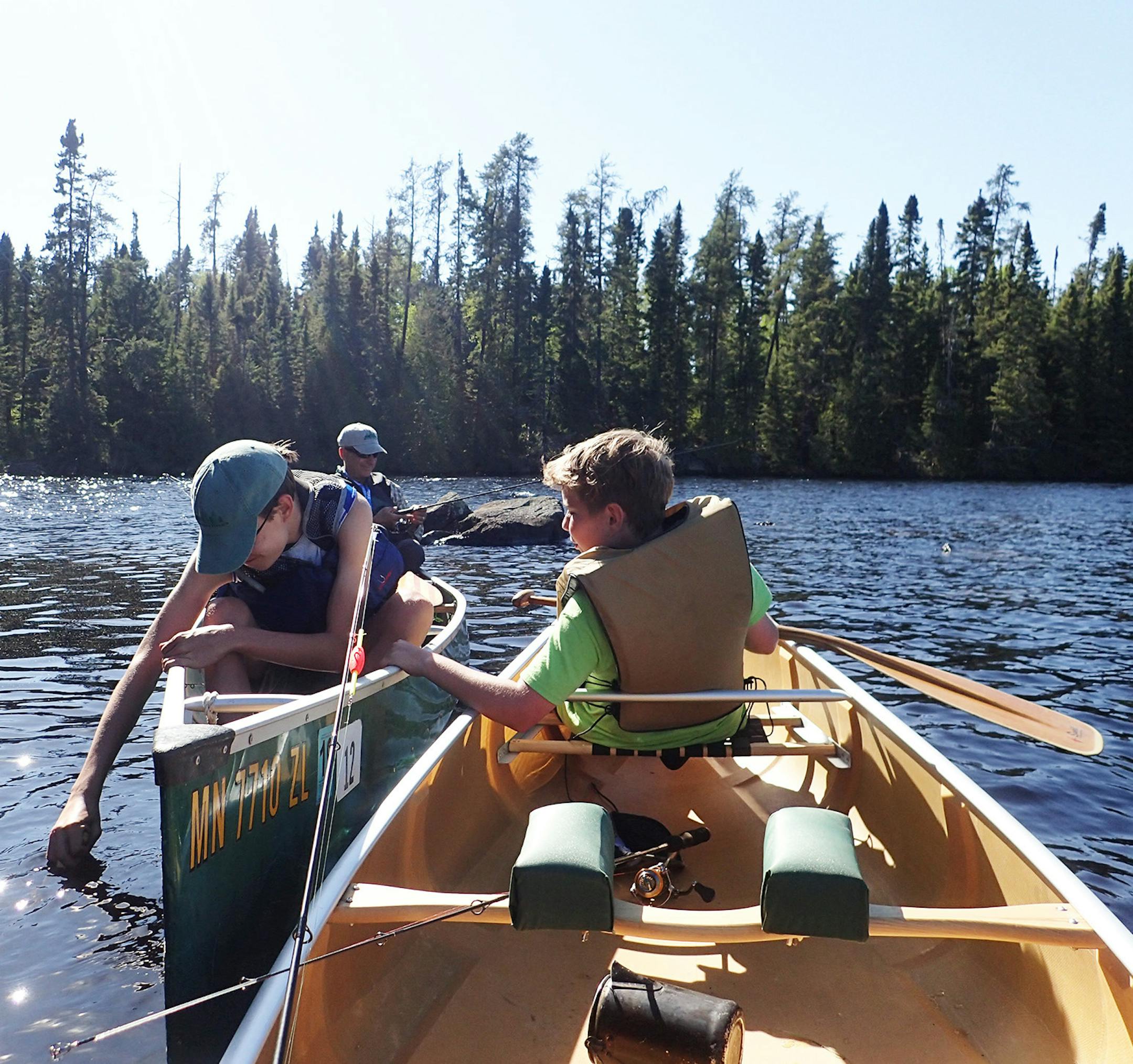 Cal Kennedy, 16, (left), tests the waters of Sawbill Lake with his hand while he and his cousin, Joe Kennedy, take a break from paddling while out of the wind.
