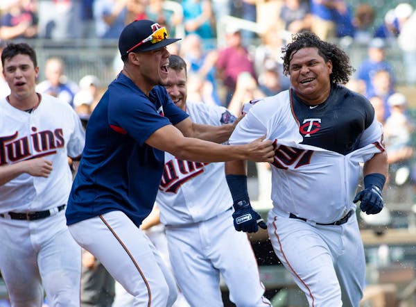 Willians Astudillo, right, was mobbed by teammate Jose Berrios after hitting a two-run walk-off home run on Sept. 9.