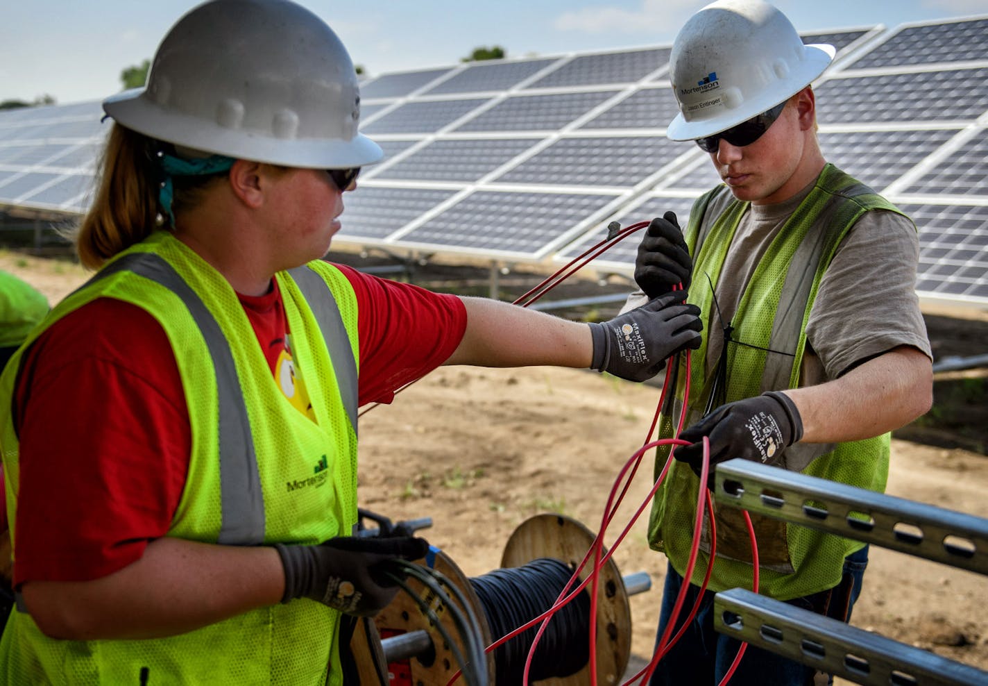 Candace May and Jason Entinger prepare wiring at a large solar project at the Blue Lake Wastewater Treatment Plant in Shakopee. ] GLEN STUBBE * gstubbe@startribune.com Thursday September 3, 2015 Workers are completing a large solar project at the Blue Lake Wastewater Treatment Plant in Shakopee that will supply electricity to it and a fertilizer operation. This is one of four solar projects in the works at the Metropolitan Council. The others are shared-solar projects called community solar gard