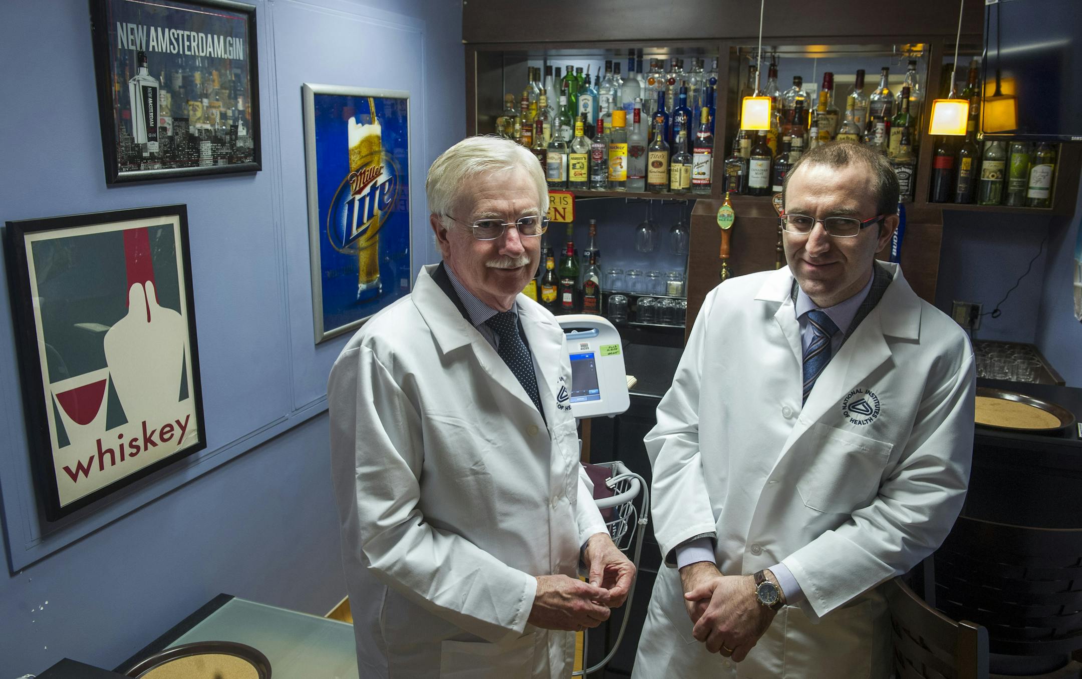 In this Dec. 19, 2014 photo, Dr. George Koob, director of the National Institute on Alcohol Abuse and Alcoholism, left, and NIAAA scientist Dr. Lorenzo Leggio pose for a photograph in a research laboratory designed as a bar inside the National Institutes of Health’s hospital in Bethesda, Md. Leggio uses the lab to test how research volunteers react to a possible new way to curb heavy drinking, part of a broader hunt for more medications to help fight alcohol abuse. (AP Photo/Cliff Owen)
