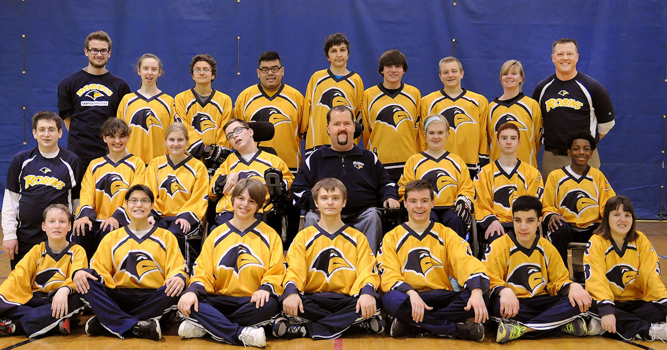 Coach Marcus Onsum (back row, far right) with this year's Robbinsdale Robins (PI) adapted floor hockey team.