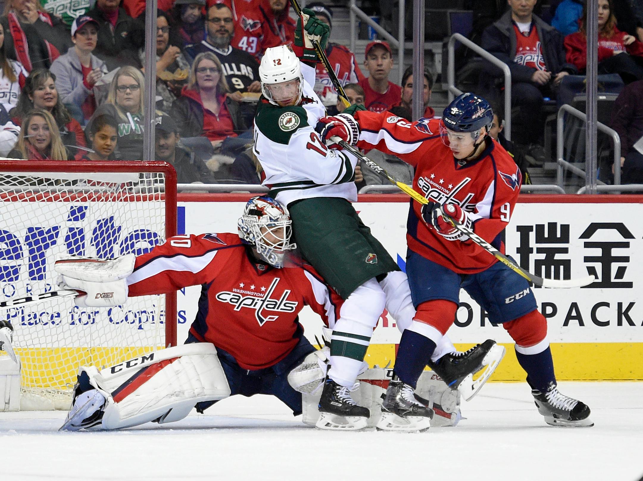 Minnesota Wild center Eric Staal (12) gets stuck between Washington Capitals goalie Braden Holtby (70) and defenseman Dmitry Orlov (9), of Russia, during the first period of an NHL hockey game, Tuesday, March 14, 2017, in Washington. (AP Photo/Nick Wass)